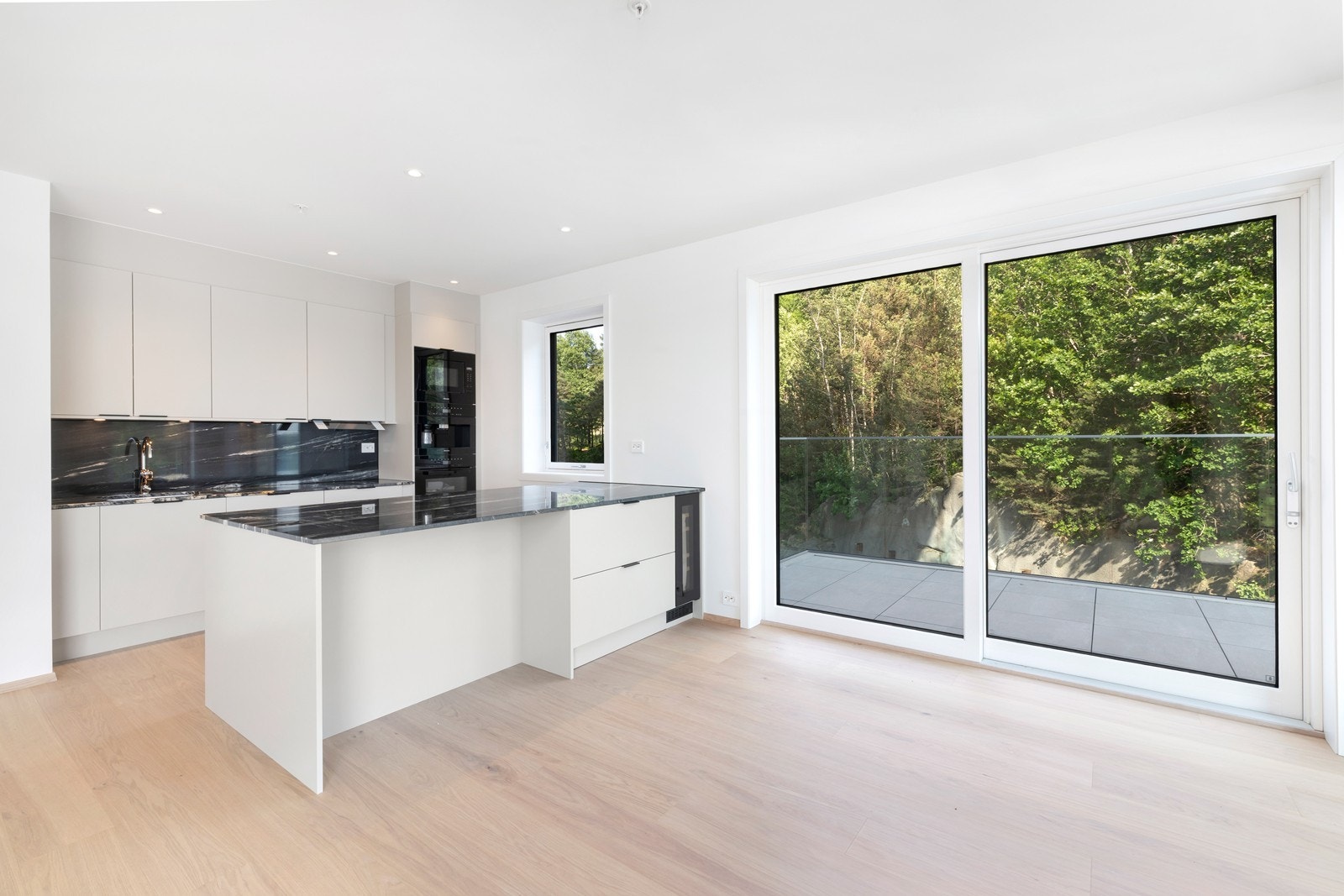 Stuen er åpen mot påkostet kjøkken fra Strai med integrerte hvitevarer. Galleribilde