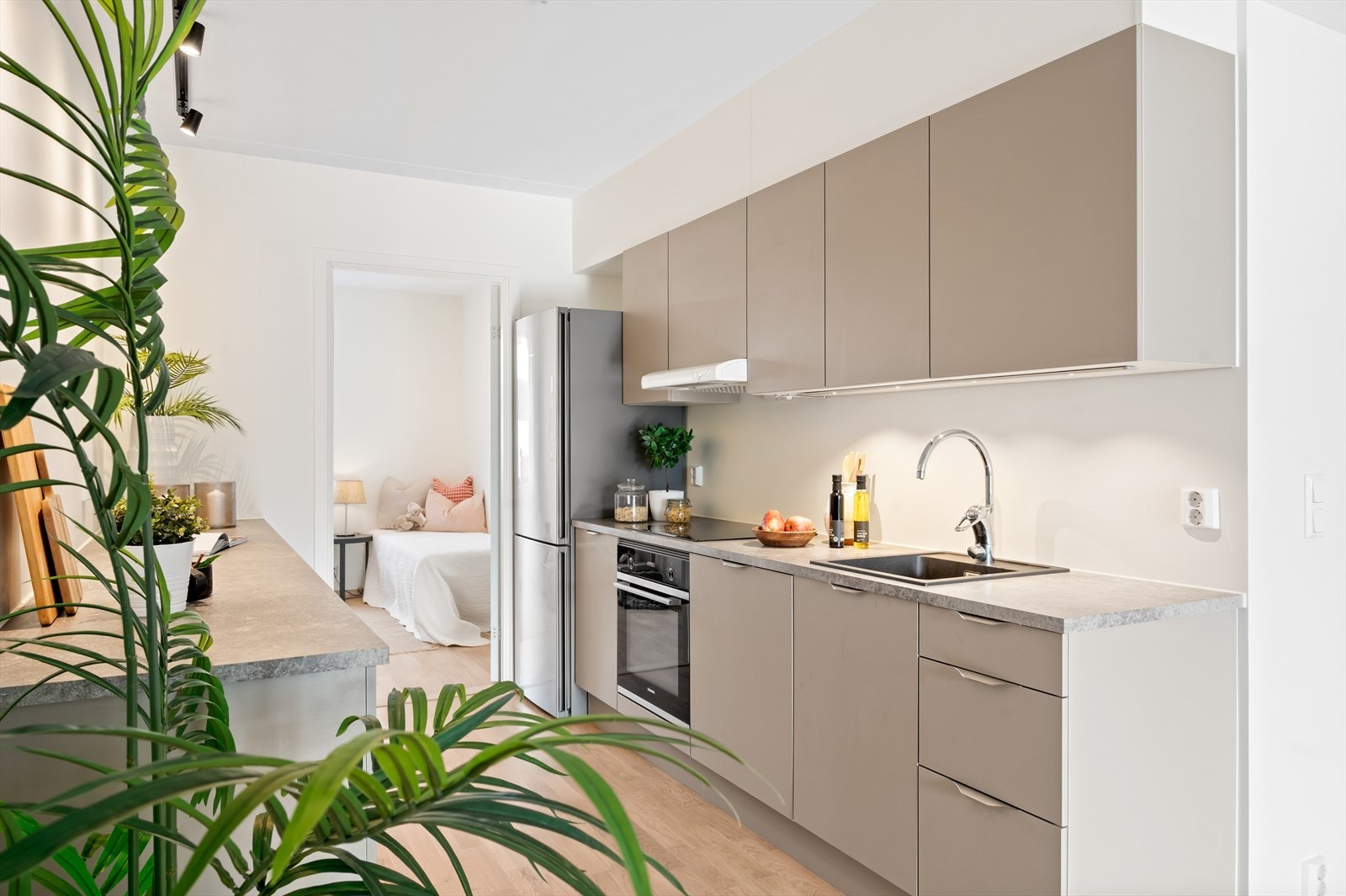 Kjøkkenet er utstyrt med glatte skapfronter i en elegant og nøytral fargetone, kombinert med laminat benkeplater som gir god arbeidsflate og et helhetlig utrykk. Galleribilde