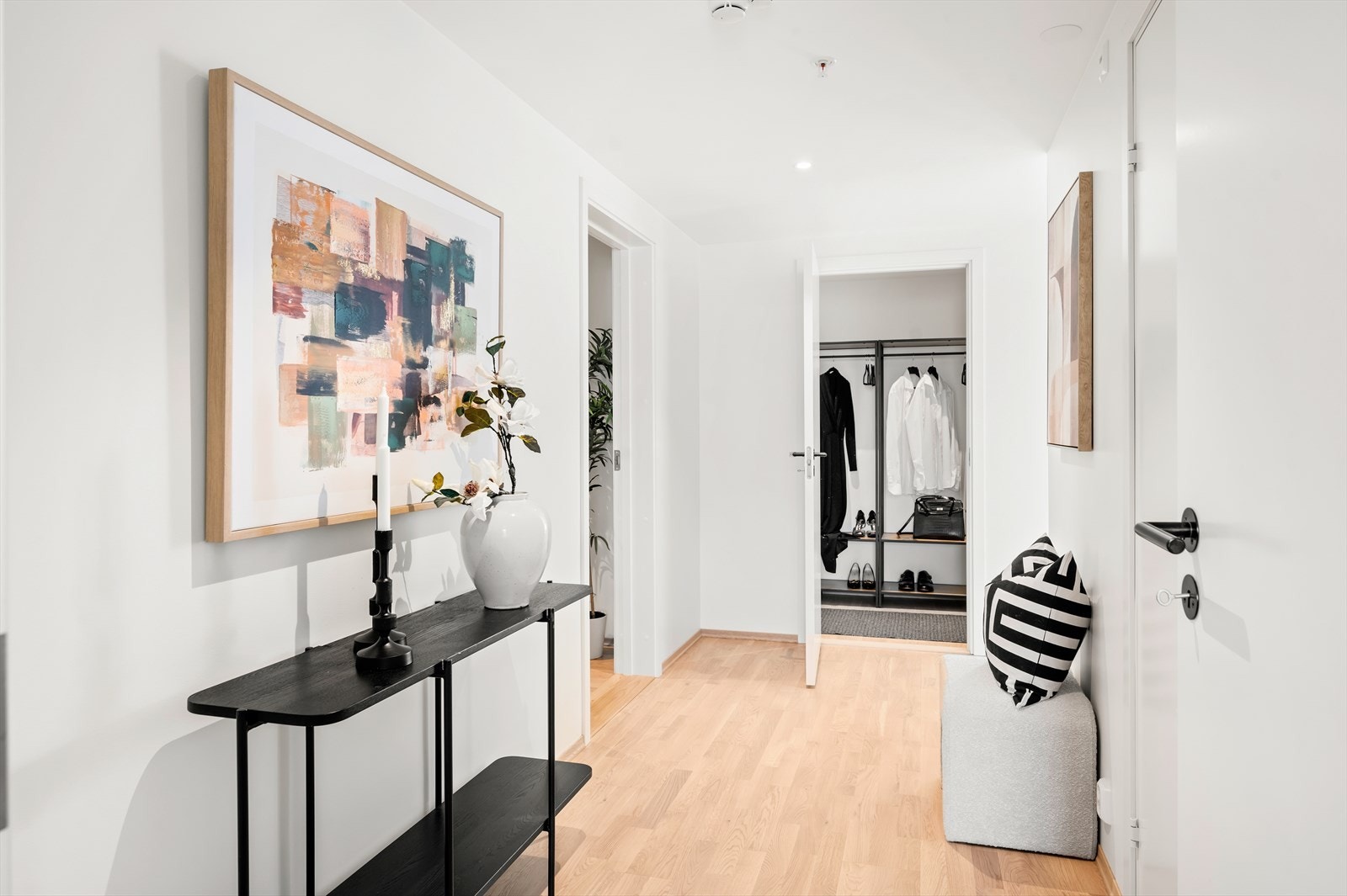 Fra entréen ledes du videre inn i en gang som binder sammen leilighetens øvrige rom på en naturlig og funksjonell måte. Galleribilde