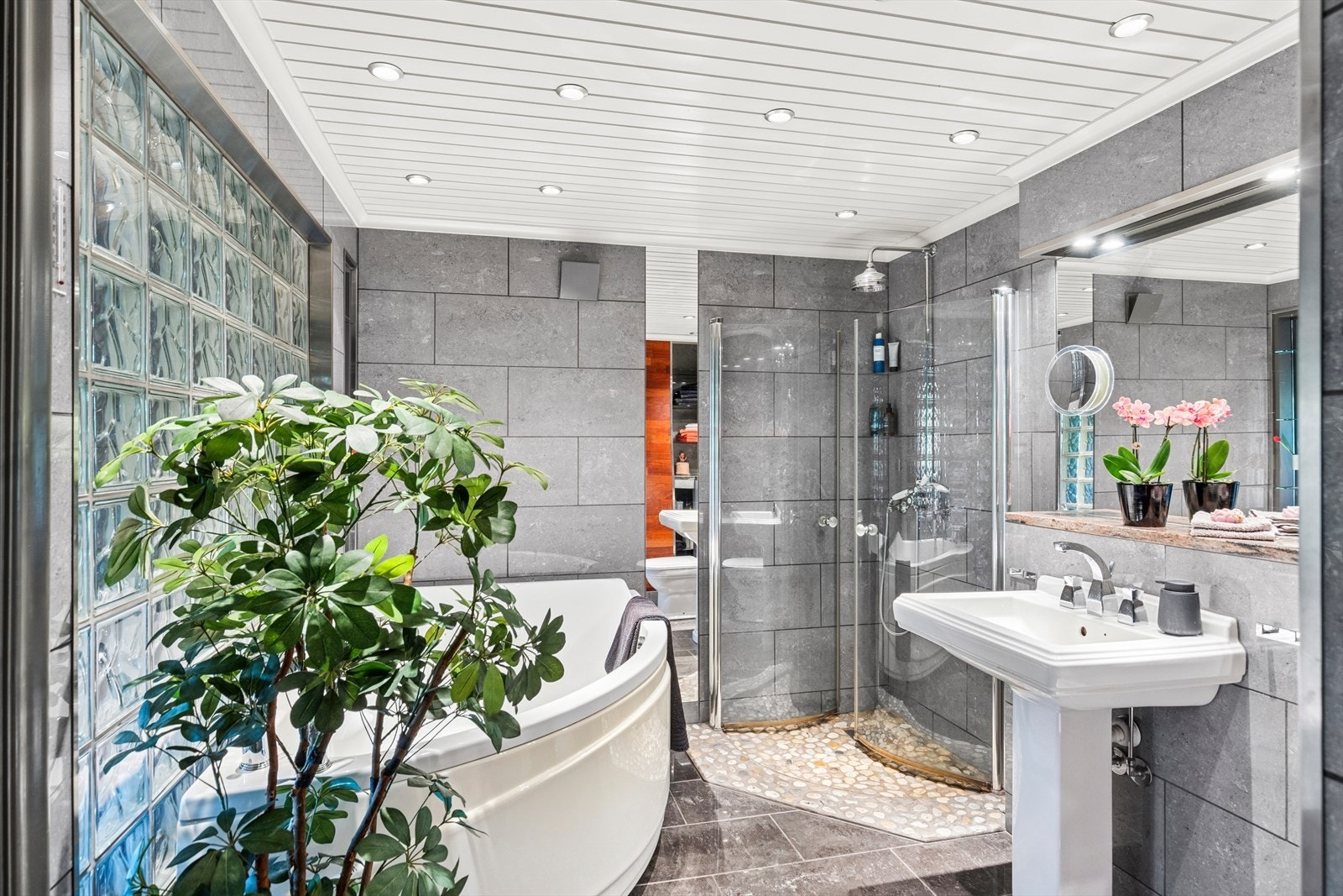 Badet er utstyrt med servant, veggmontert toalett, badekar og dusjhjørne. Det er mekanisk avtrekk. Galleribilde