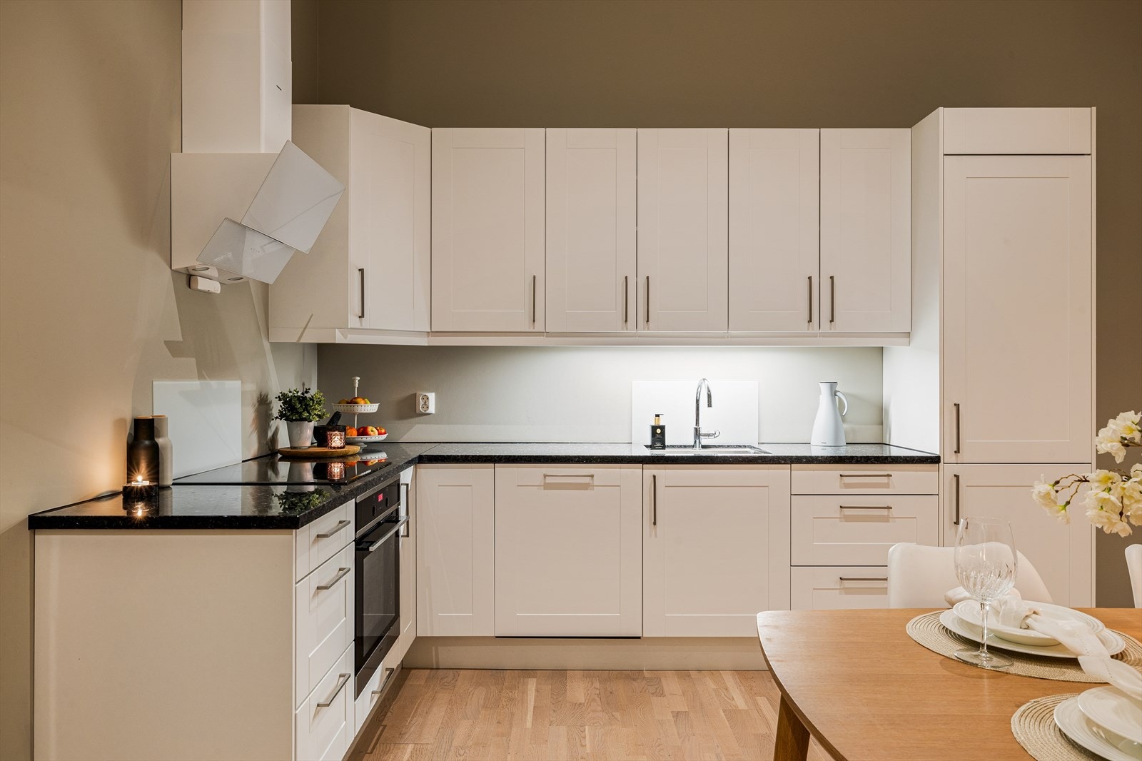 Stilrent kjøkken med profilerte fronter, steinbenkeplate og integrerte hvitevarer. Galleribilde