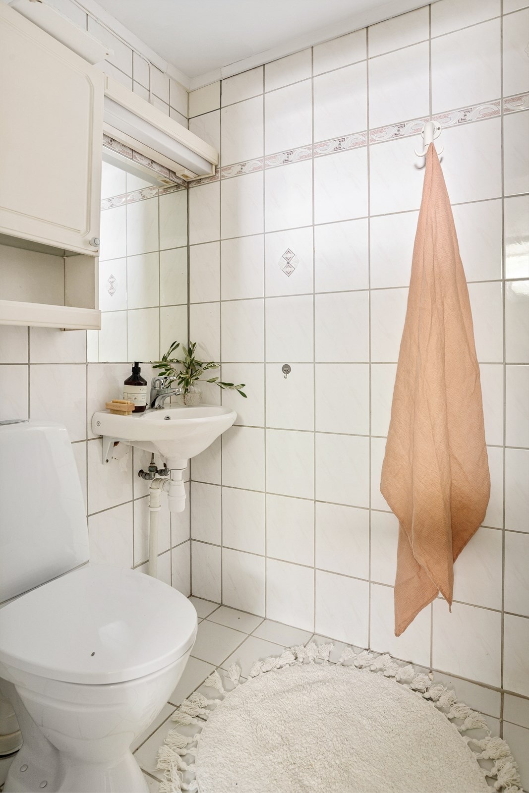 Innredning består av åpen dusjplass med blandebatteri, frittstående toalett, servant med ett-greps blandebatteri og sideskap med speil og lys. Galleribilde