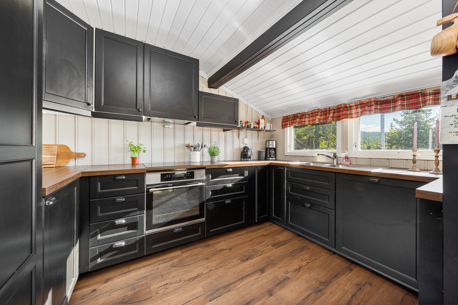 Kjøkkenet har klassisk innredning med sorte, profilerte fronter og laminert benkeplate. Galleribilde