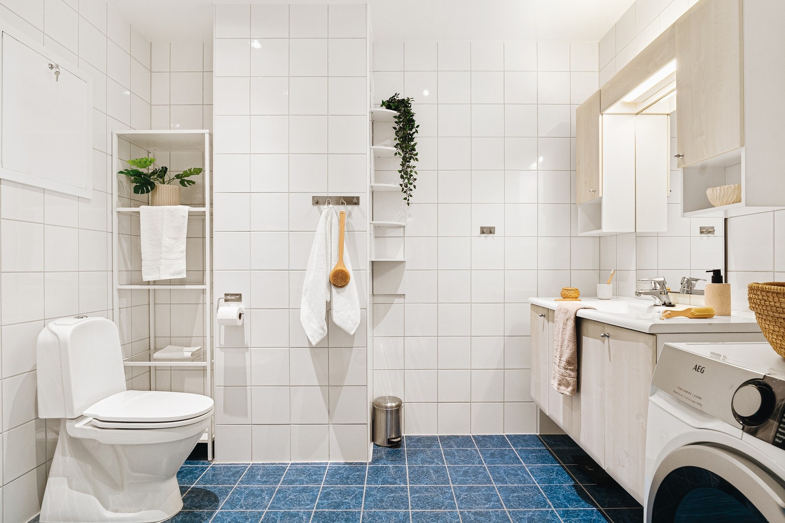 Baderomsinnredningen består av toalett, helstøpt servant, skuffer under servant med slette fronter, og dusjdører i klart glass, med opplegg for vaskemaskin. Galleribilde