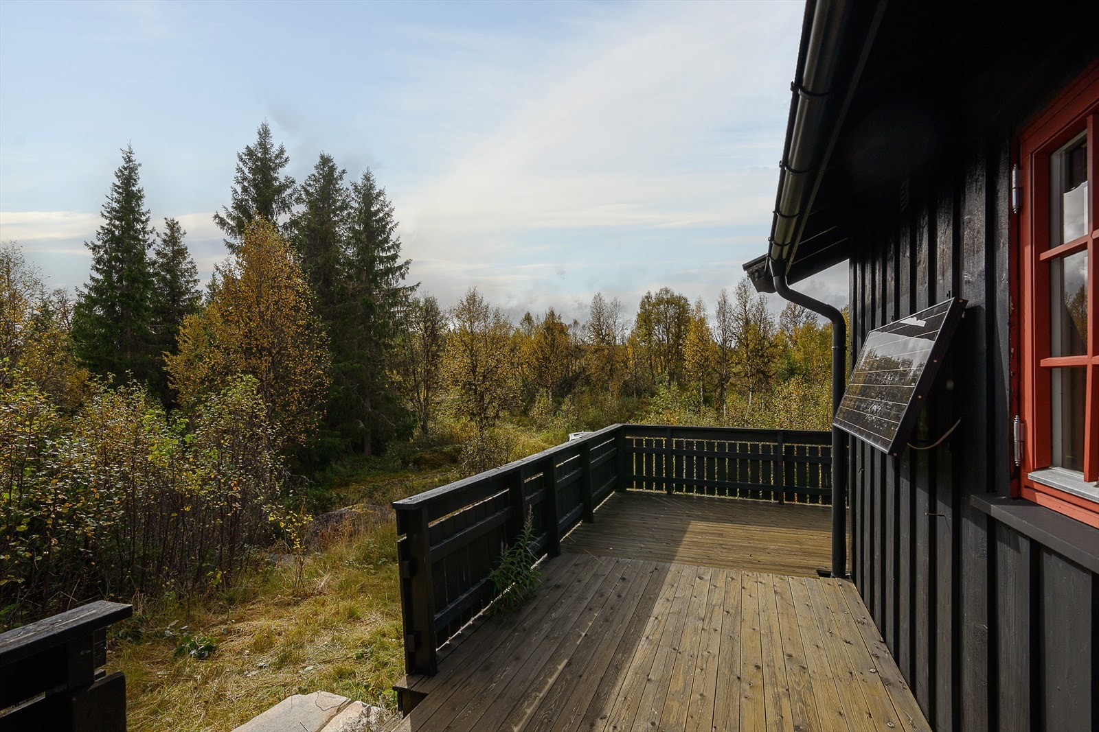 Terrasse ved inngangsdør. Solcellepanel på vegg, og det er bilvei helt frem. Galleribilde