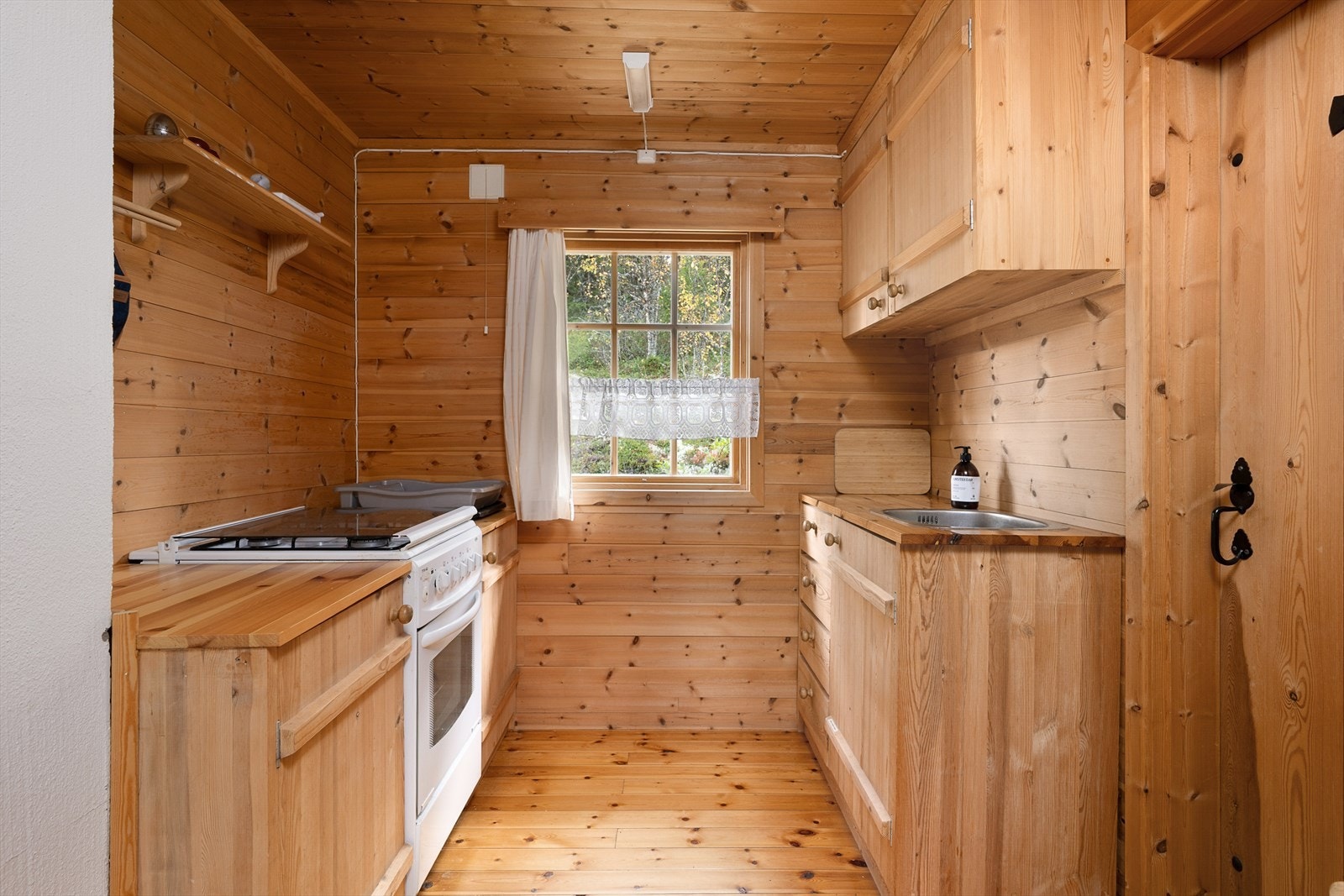 Enkel kjøkkeninnredning med glatte fronter og heltre benkeplate. Galleribilde