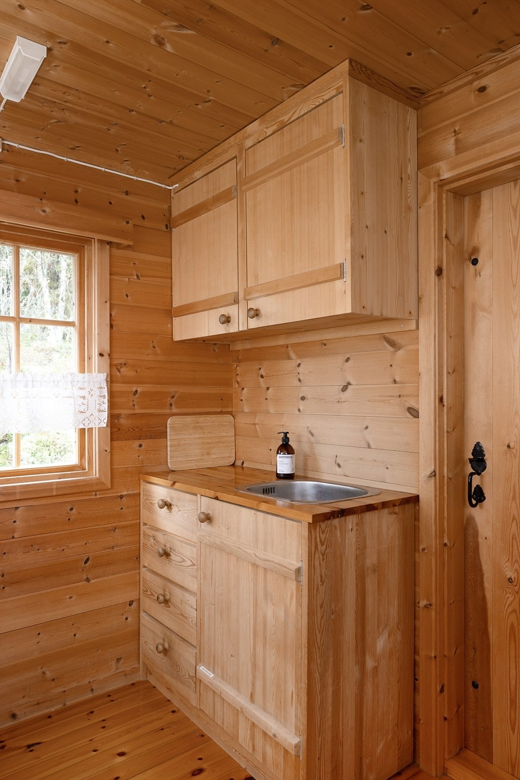 Avløp ført ut i terrenget. Gassbeholder står ifm. kjøkkeninnredningen. Galleribilde