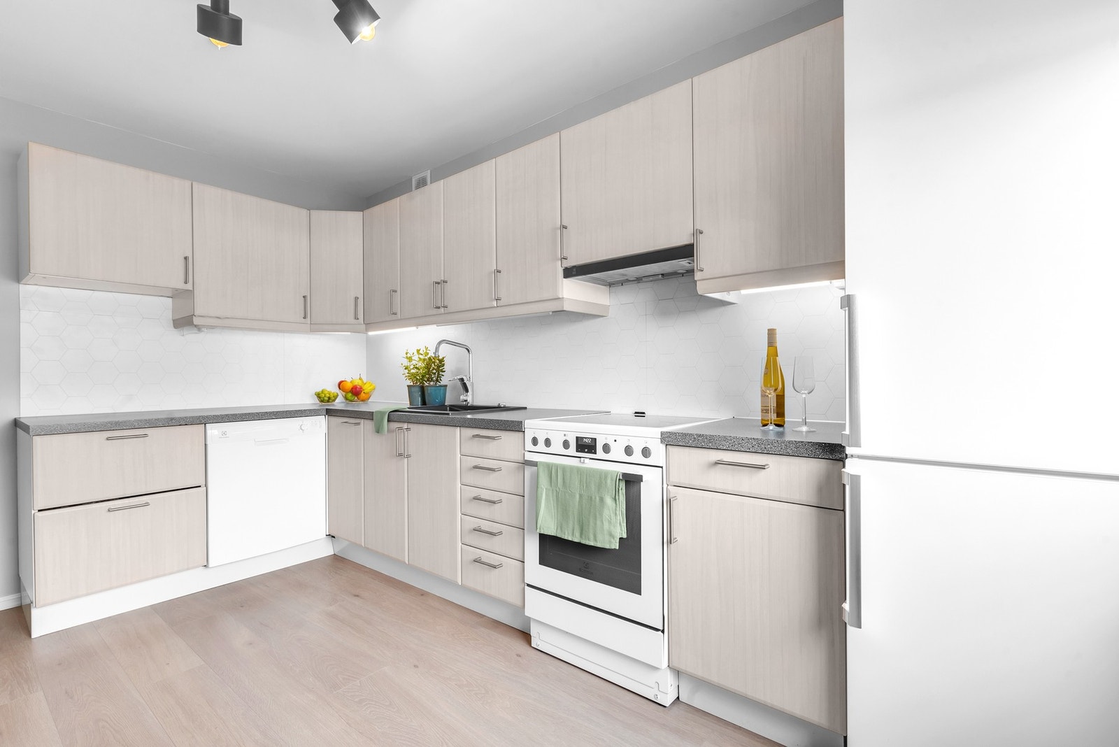 Alle hvitevarer medfølger. Innredningen består av glatte, folierte fronter, laminat benkeplate med nedfelt kum, flislignende plater på vegg over benk, ledlys under overskap samt opplegg til oppvaskmaskin. Det er montert komfyrvakt samt aquastopp. Galleribilde