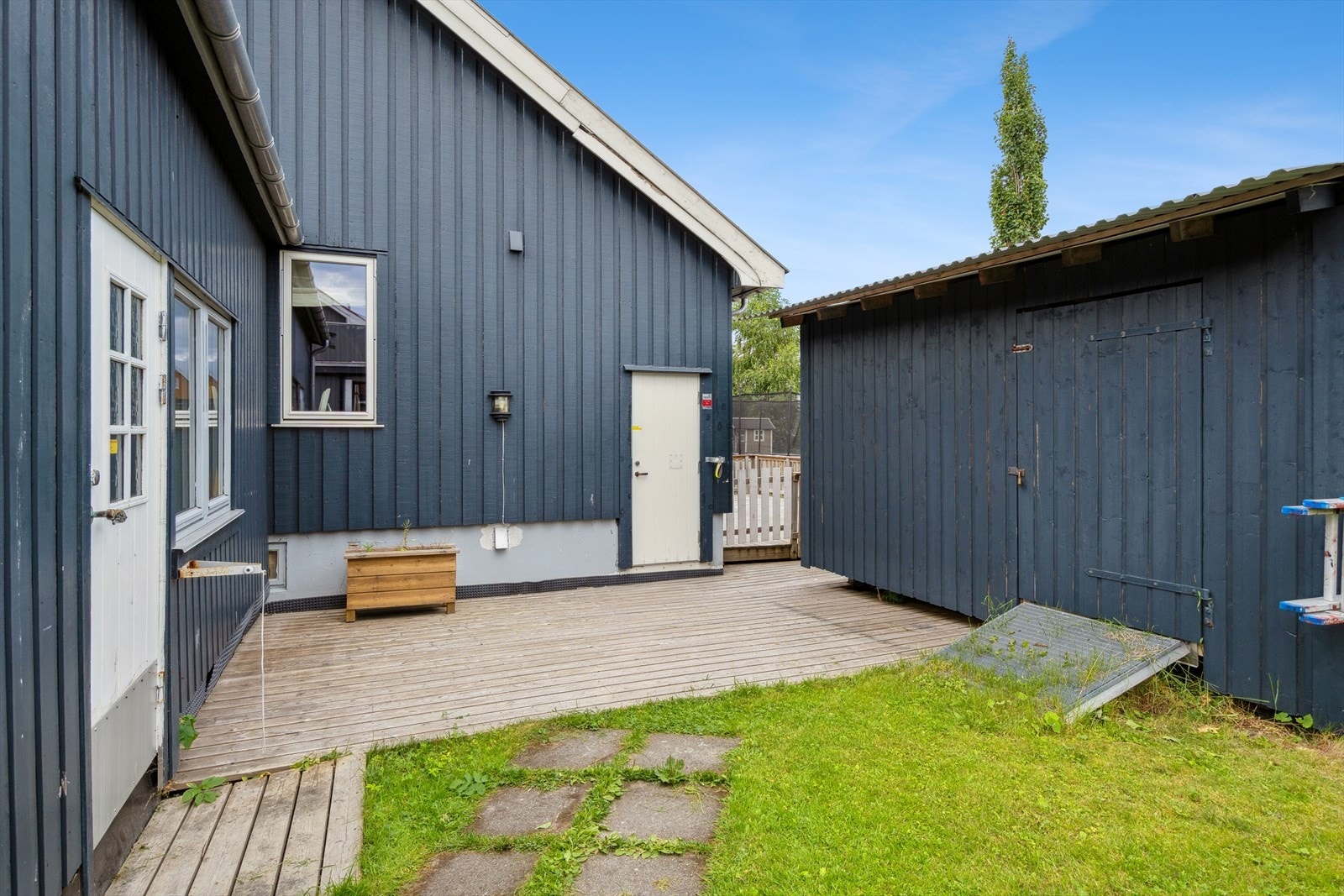 Bakhage med adkomst til garasjen, kjelleretasjen og uteboden. Galleribilde