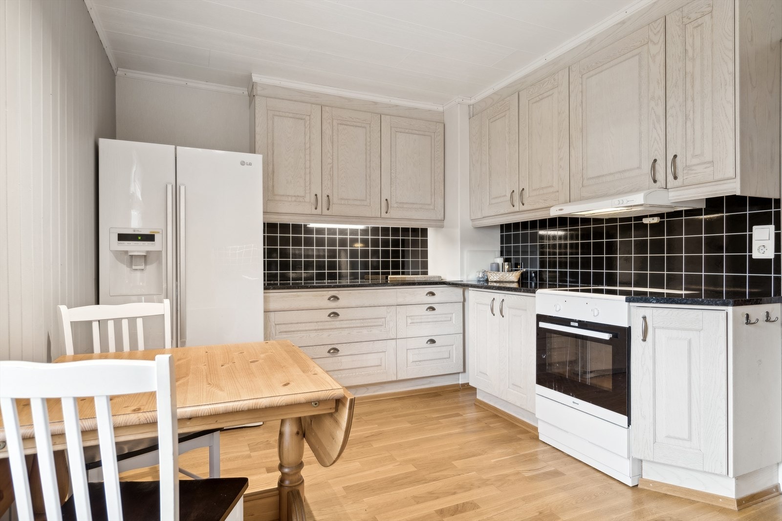 Hvitevarene medfølger og består av komfyr, oppvaskmaskin og side-by-side kombiskap - Det er etablert kjøkkenventilator med mekanisk avtrekk, komfyrvakt og vannsensor Galleribilde