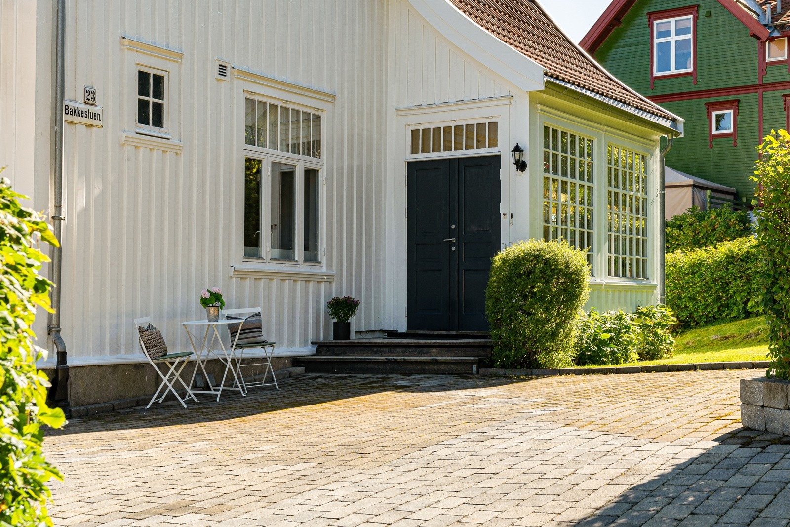 Boligen er pent opparbeidet med belegningsstein, hage, markterrasse og to inngangsdører. Galleribilde