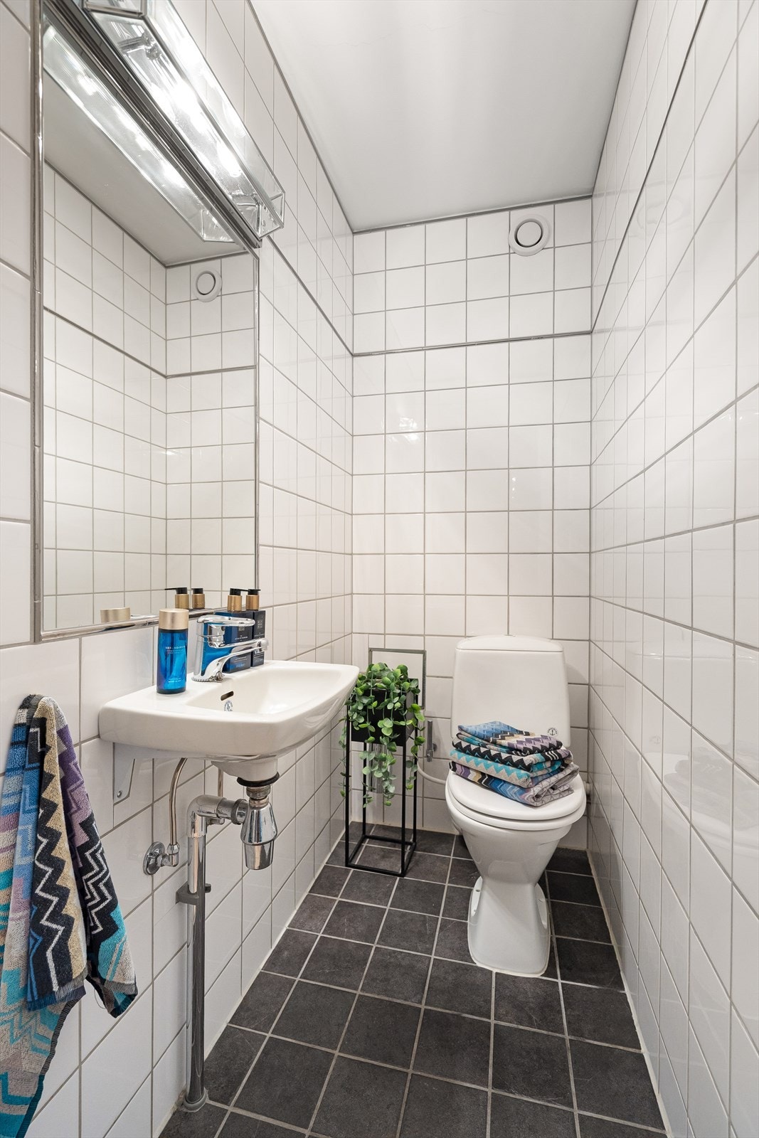 Separat toalett med adkomst fra gangen. Rommet har flislagte overflater og elektrisk gulvvarme, og er utstyrt med gulvstående toalett og servant med ettgreps armatur fra Oras. Galleribilde