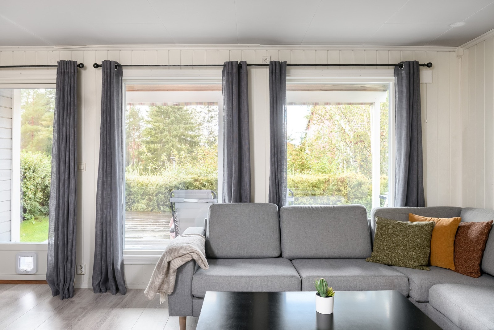 Dagslyset strømmer inn via store, vestvendte vinduer i stuen. Galleribilde