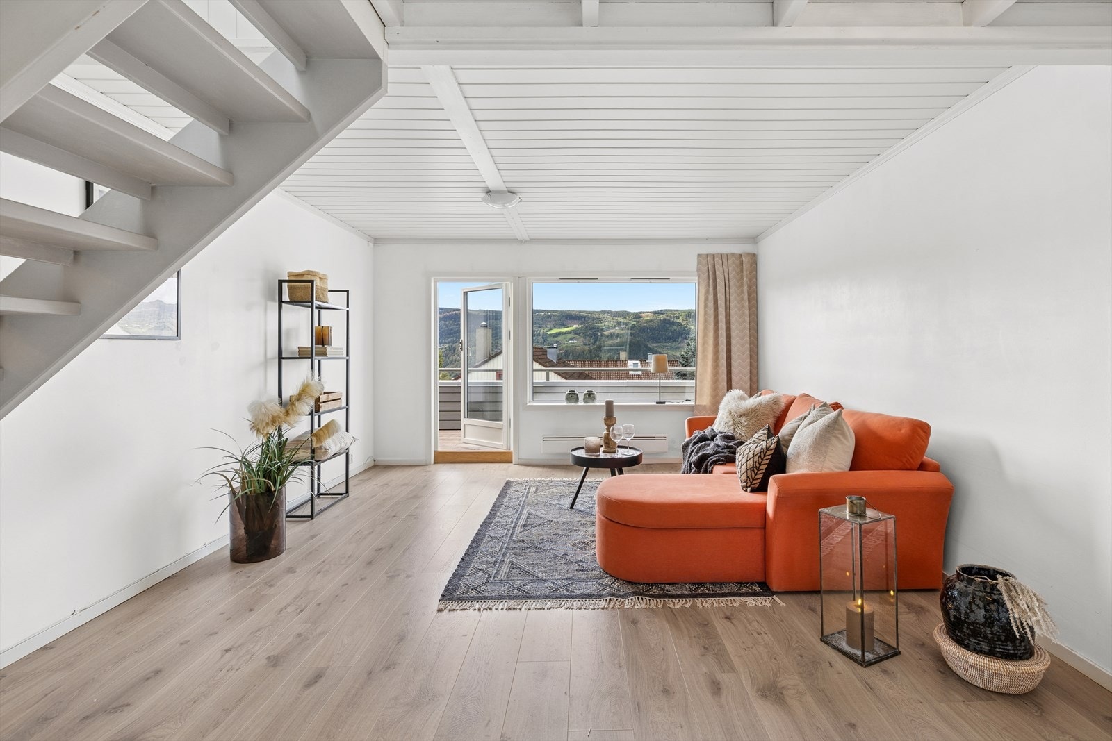 Rommet har en stor vestvendt vindusflate som slipper inn rikelig med naturlig lys og gir noe utsikt, samt utgang til den solrike balkongen via dør med stort glassfelt Galleribilde