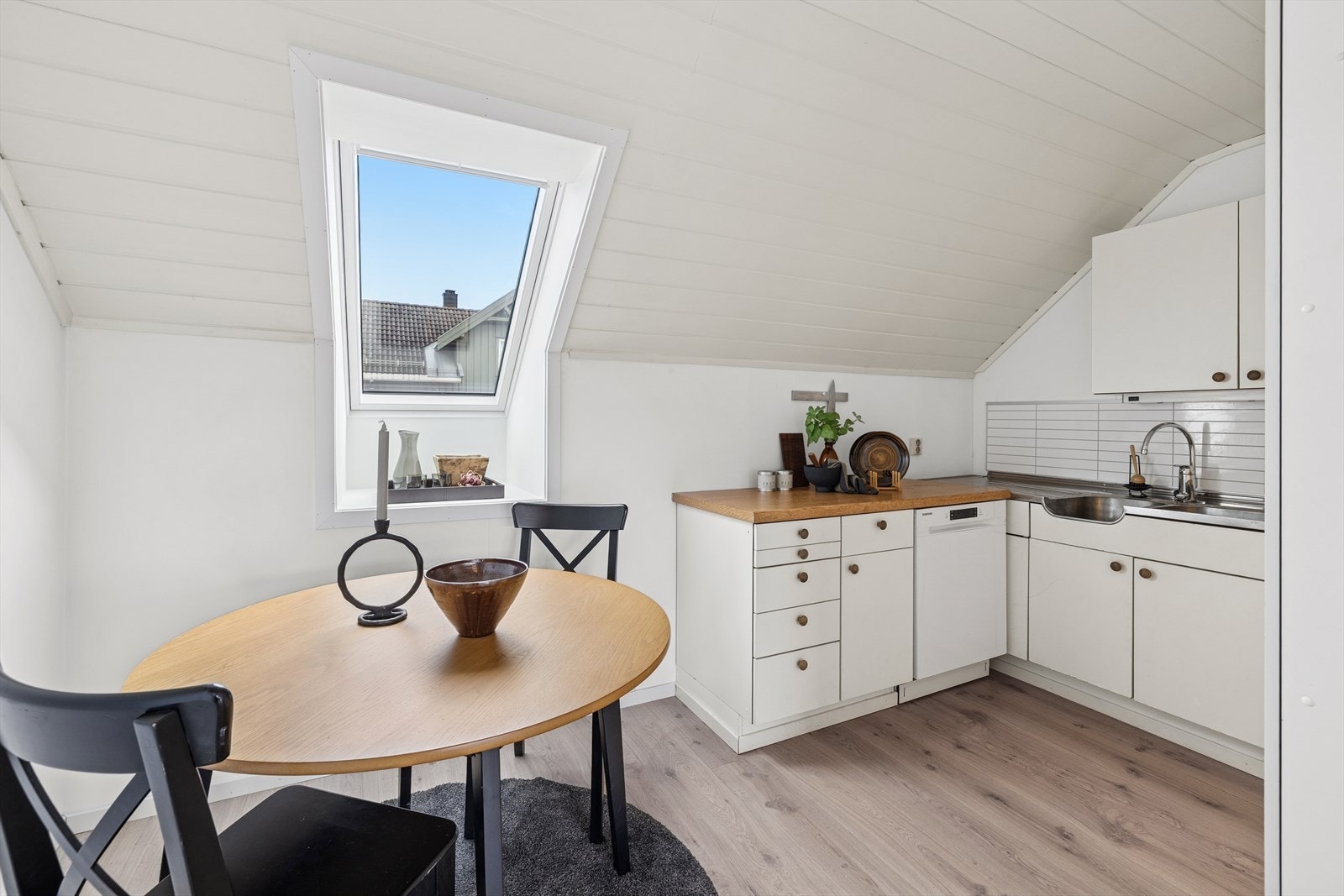 Kjøkkenet har en tidløs innredning med hvite, slette fronter Galleribilde