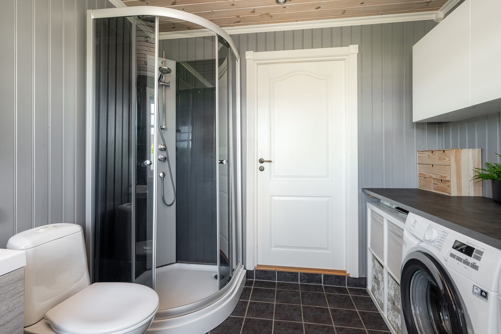 Vaskerommet/ badet har tilkomst fra entré i 1. etasje. Det er flis på gulv med varmekabler. panel på vegg og panel med spotter i himling. Galleribilde