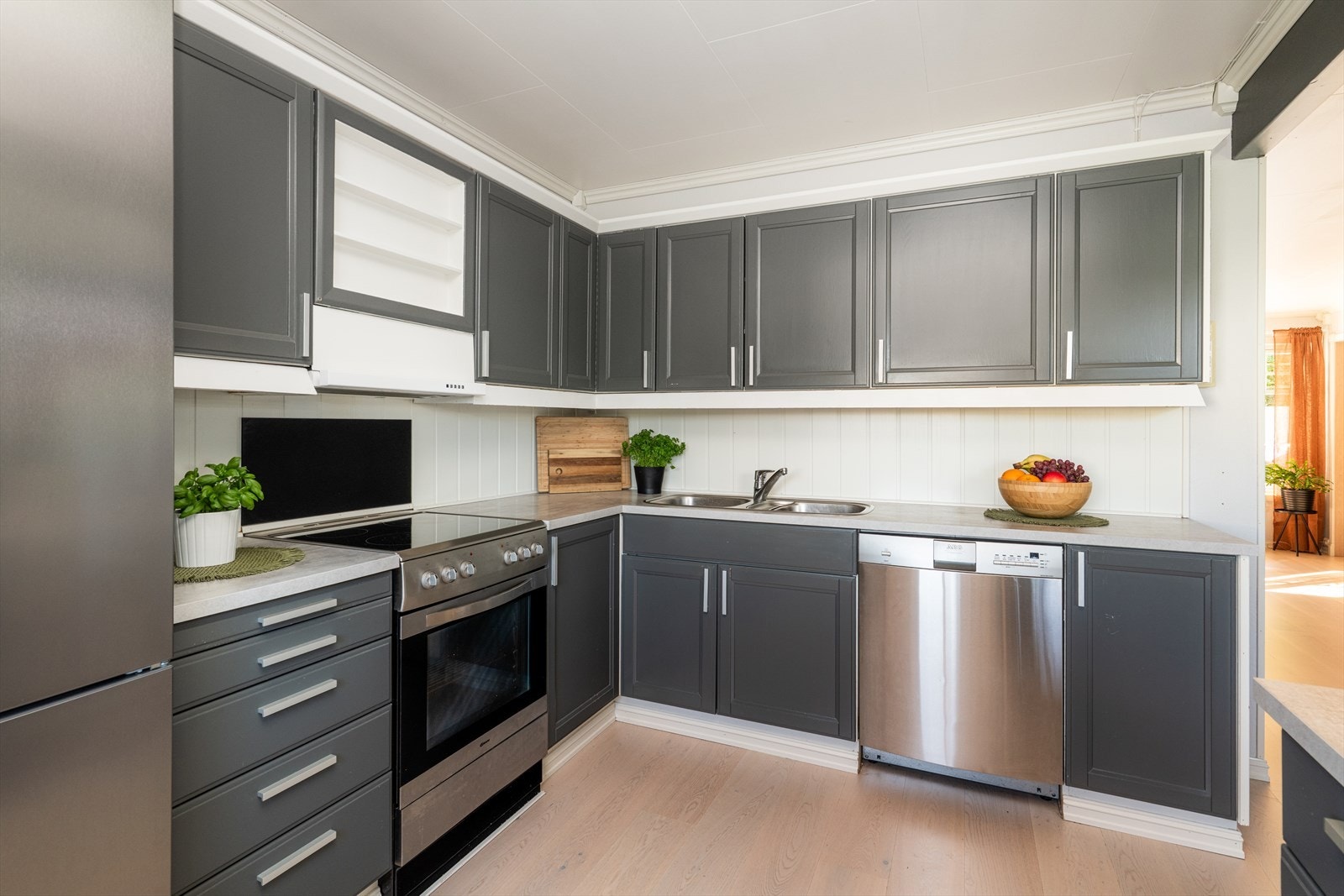 Pent kjøkken med profilert innredning og laminert benkeplate med nedfelt vask. Galleribilde