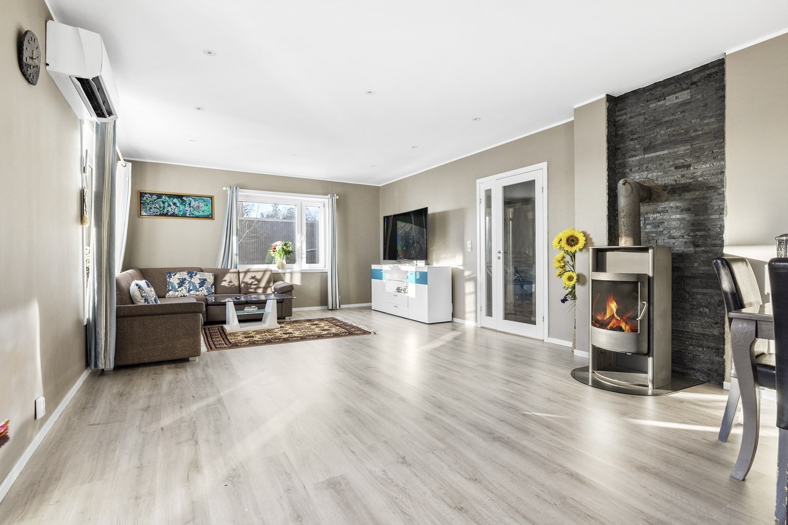 Med gjennomgående løsning og flere store vinduer oppleves stuen som lys og luftig. Galleribilde