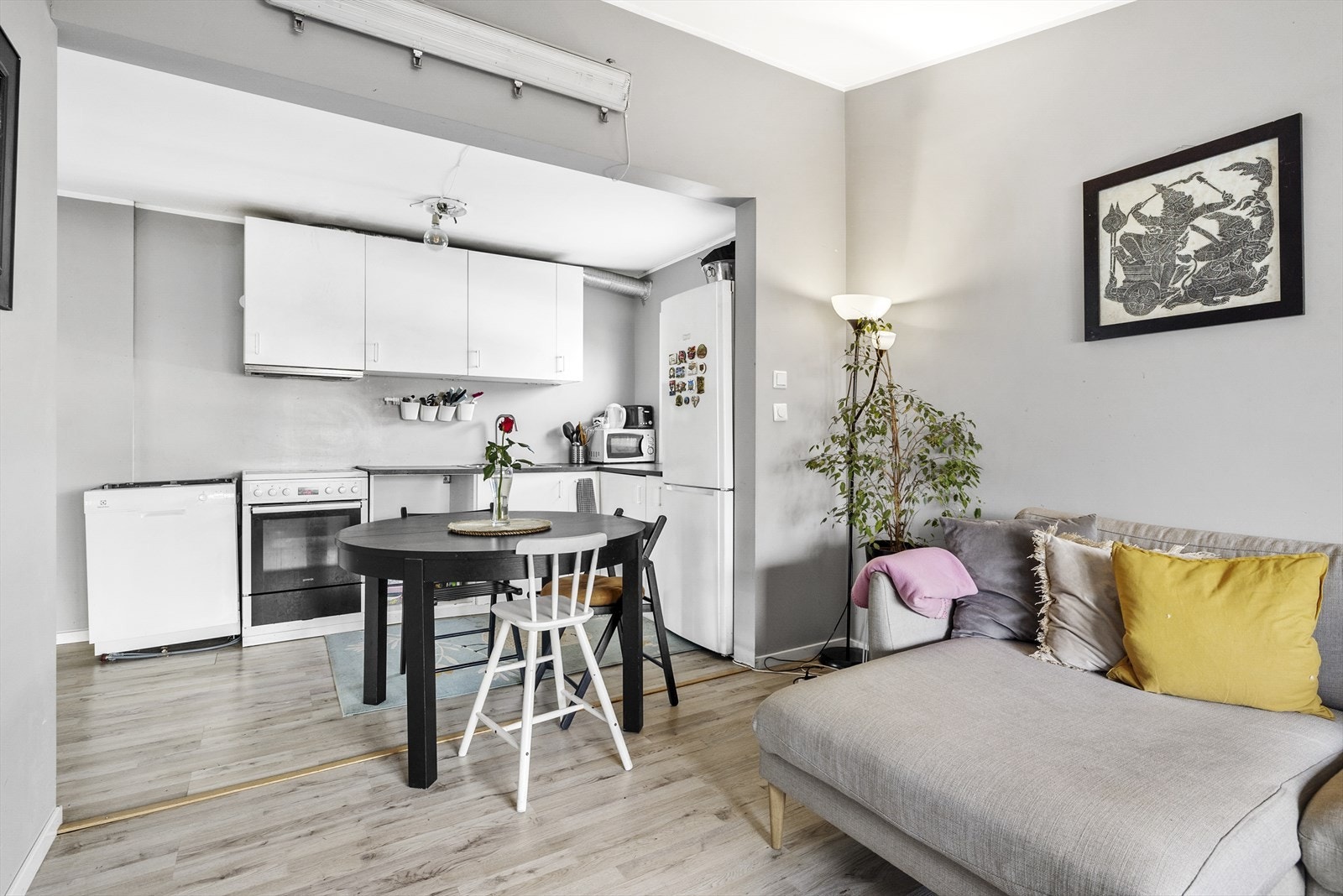 Kjøkkeninnredning med glatte folierte fronter, laminat benkeplate med nedfelt dobbel kum i rustfritt stål og ventilator. Galleribilde