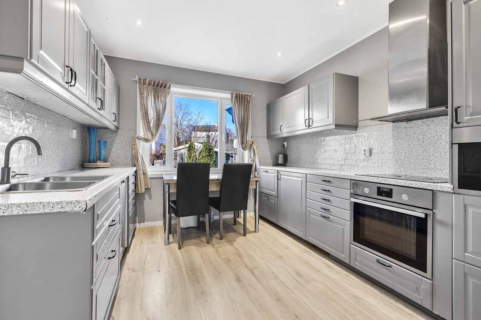 Hyggelig kjøkken med profilerte fronter, laminat benkeplate med nedfelt dobbel kum i rustfritt stål og ventilator. Induksjonstopp, stekeovn, oppvaskmaskin, mikrobølgeovn og kjøleskap er integrert i innredningen. Galleribilde