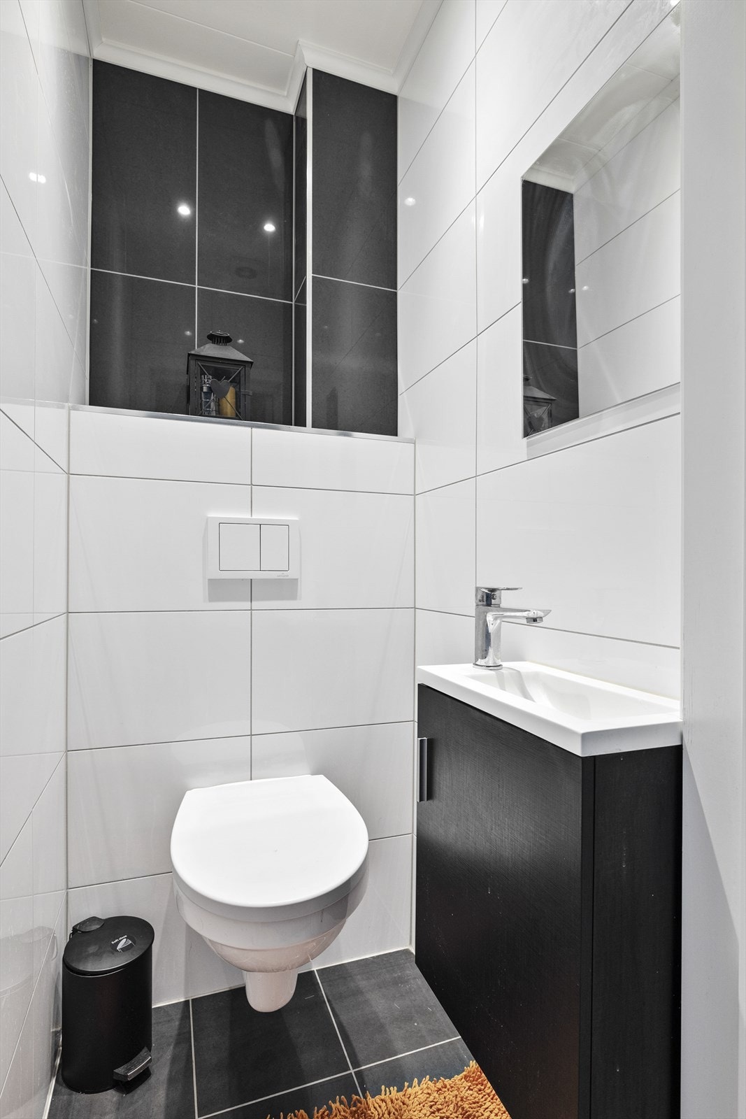 Praktisk wc med benkeskap med glatt front, servant, veggfestet klosett med innebygget sisterne. Elektrisk avtrekksvifte i himling. Galleribilde