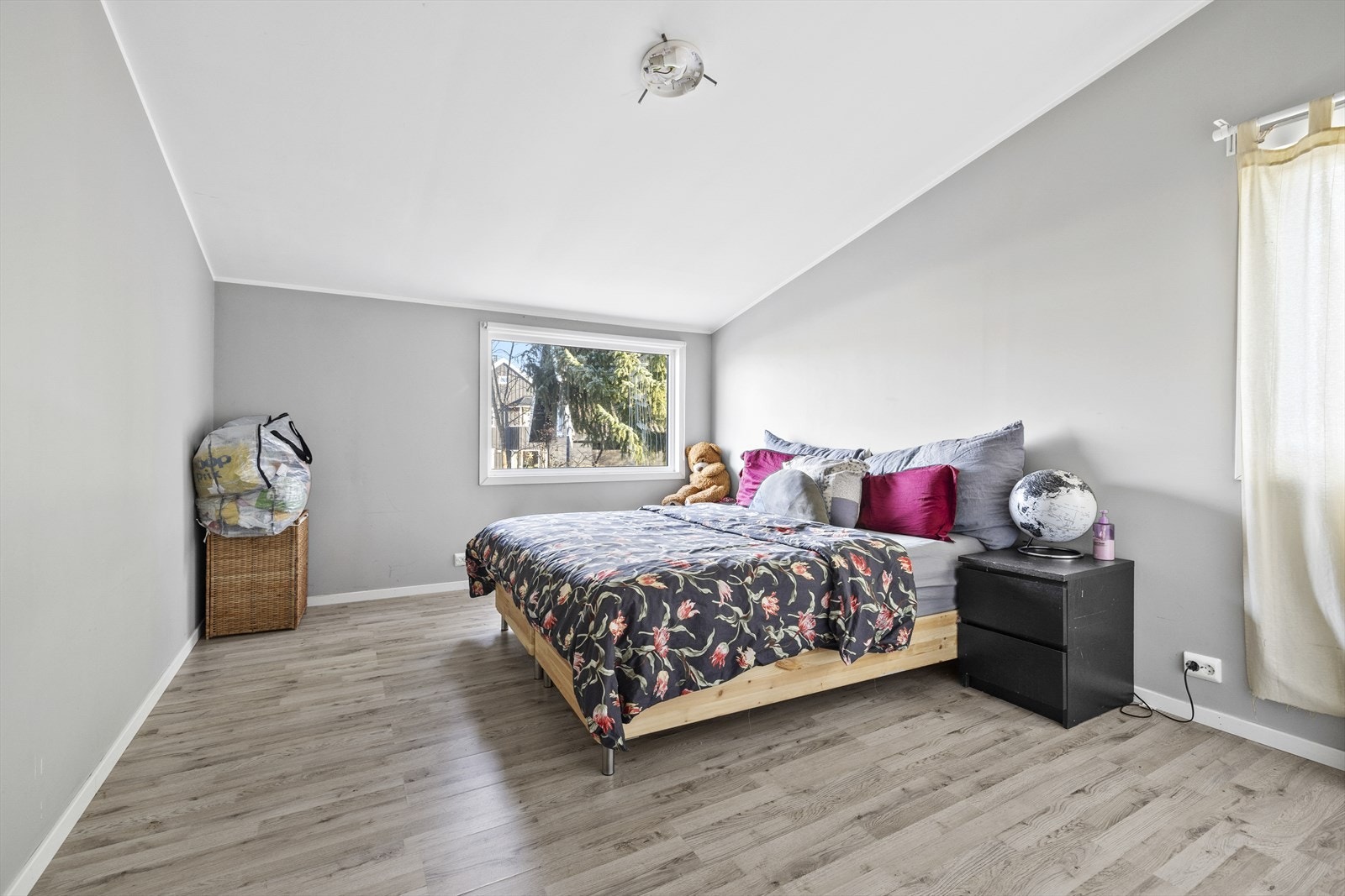 Romslig soverom med plass til dobbeltseng, nattbord og annet soveromsinteriør. Galleribilde