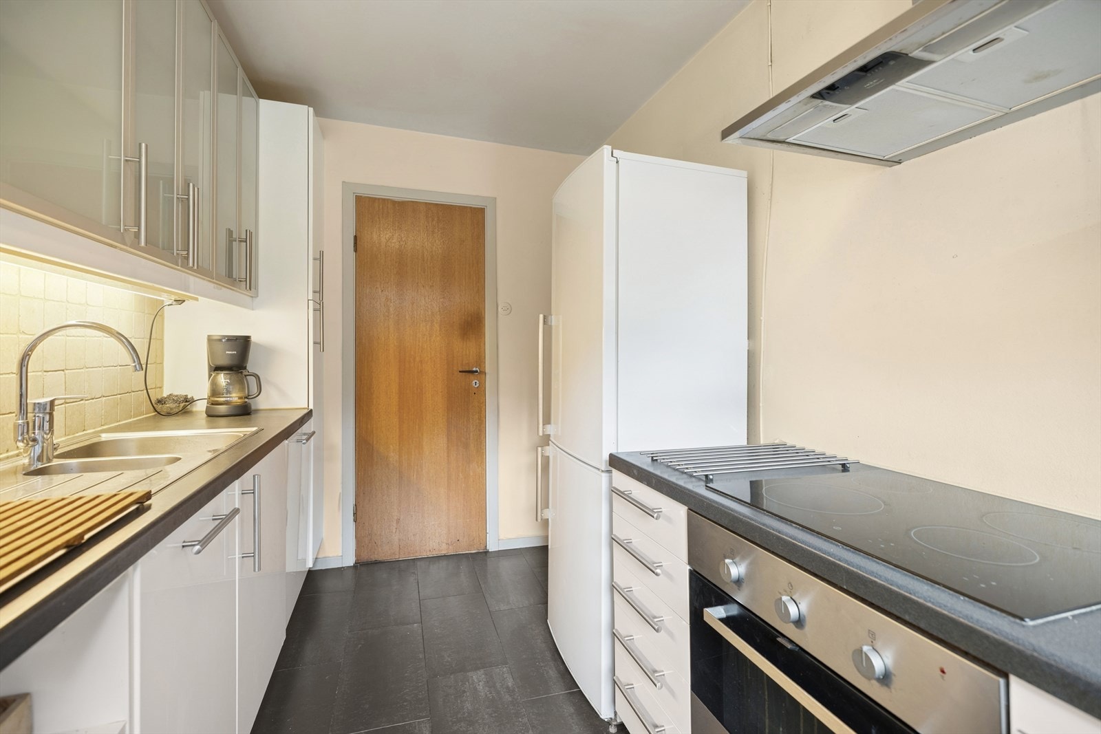 Leiligheten har et pent IKEA-kjøkken fra 2010 med høyglans laminerte fronter og overskap med frostet glass. Galleribilde