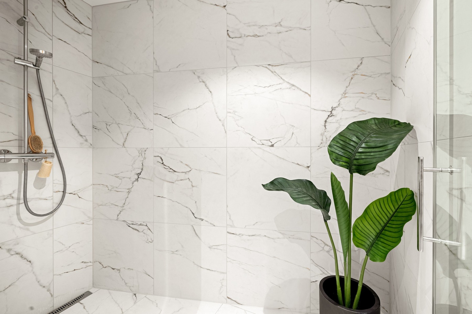 De er innredet med vegghengt toalett, dusj med glassvegger - ene i en stor nisje, og baderomsmøblement med speil og belysning. Galleribilde