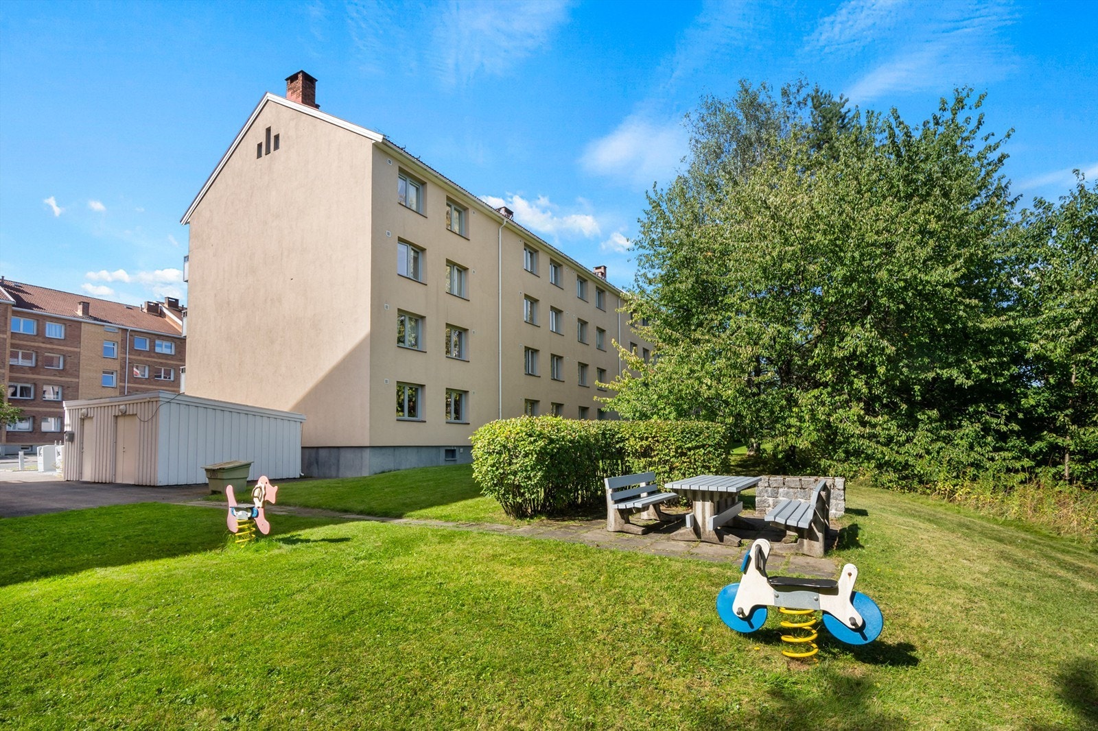 Borettslagets tomt er pent opparbeidet med flotte grøntområder på baksiden av blokken med grillplass og sittegrupper, ellers er området pent beplantet med trær og prydbusker. Galleribilde