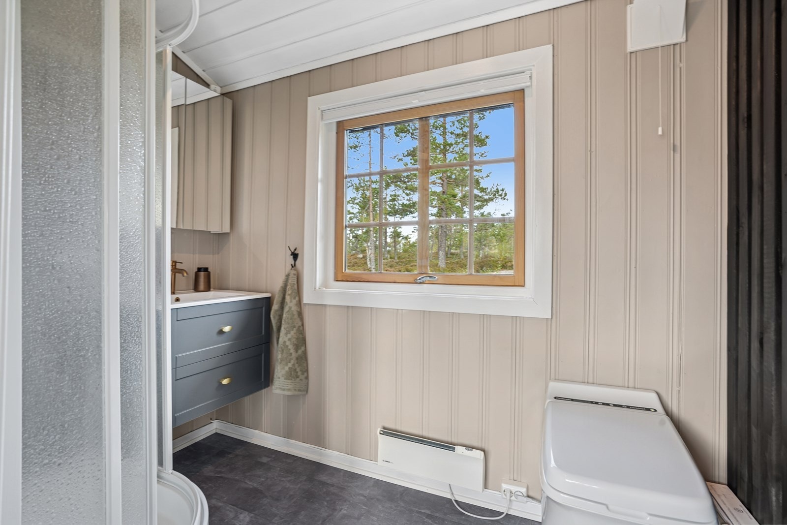 Badet har dusjkabinett og cinderella forbrenningstoalett. Galleribilde