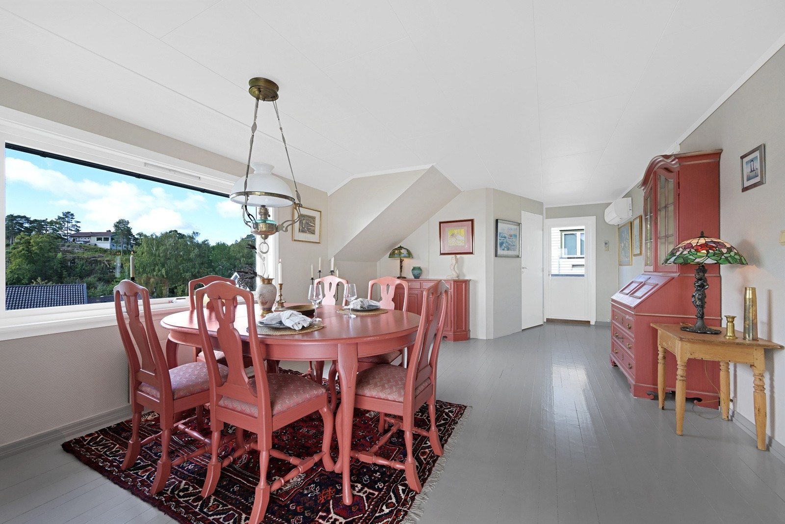 Åpen løsning stue/kjøkken med malt tregulv og store vindusflater Galleribilde