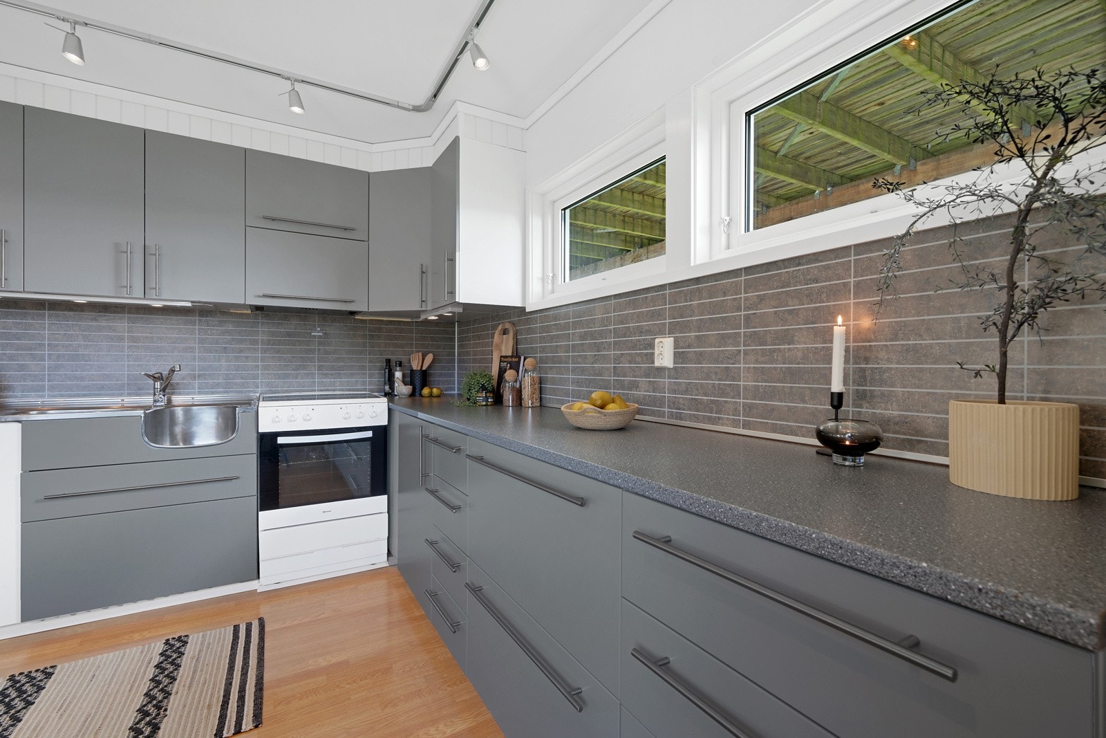 Kjøkkenet i denne etasjen har godt med benkeplass, skaper og skuffer Galleribilde