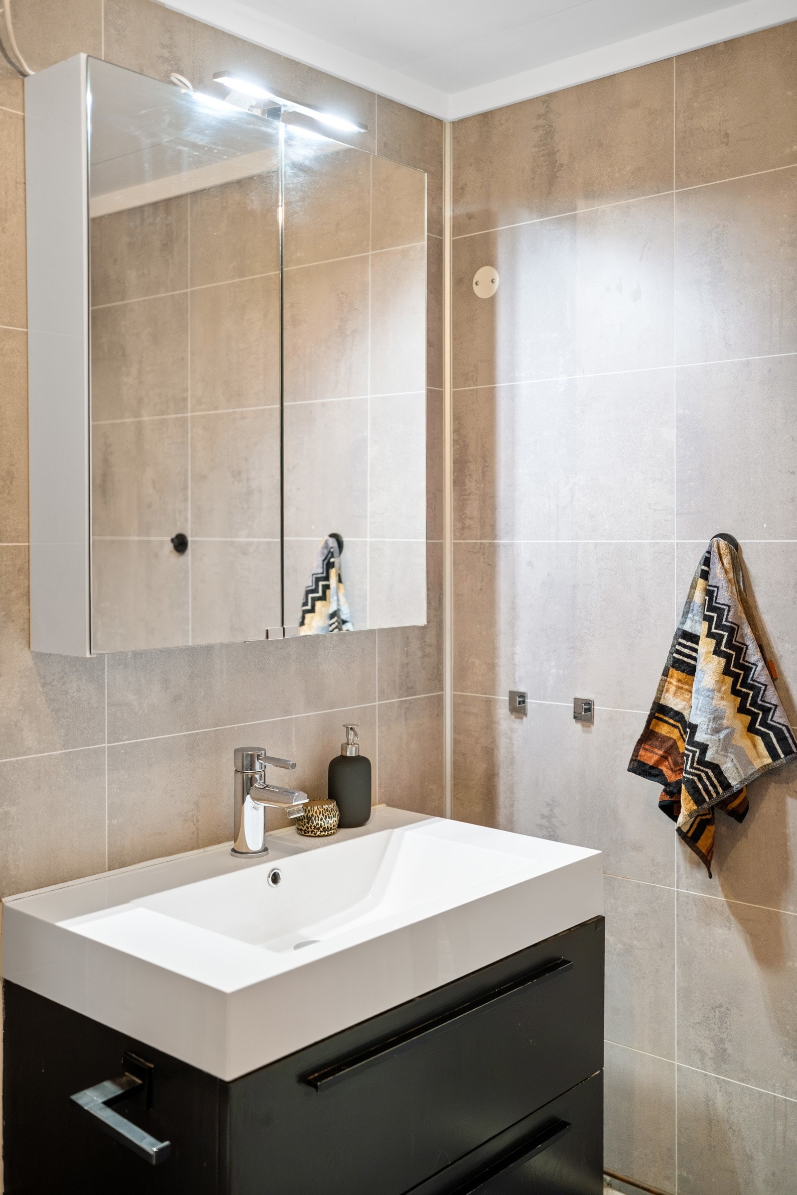 Innredning med mørke fronter og speilskap med lys. Galleribilde