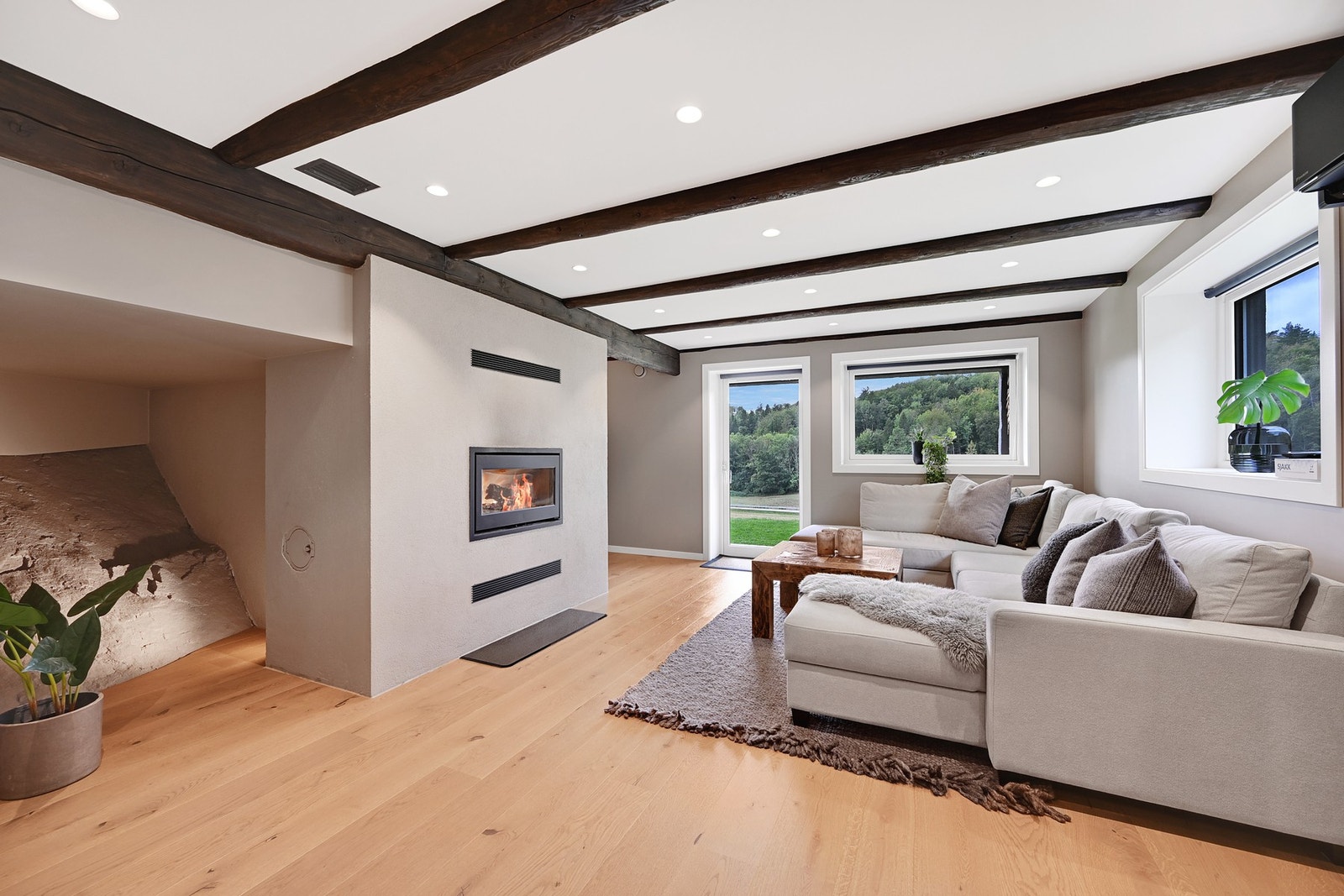 Kjellerstuen ble pusset opp i 2021 og har god plass for sofa - og peisovnen byr på moderne stil. Galleribilde