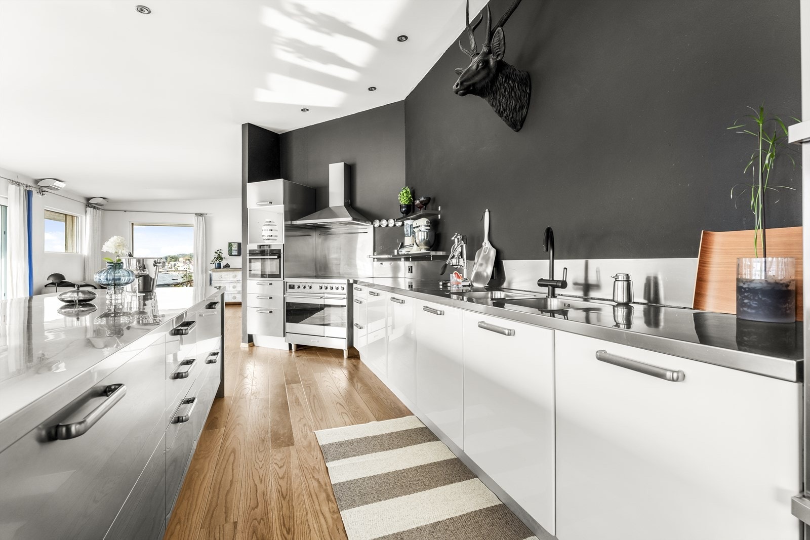 Kjøkkeninnredning med slette fronter i hvit og stål, og stål benkeplate med 2-kums utslagsvask Galleribilde