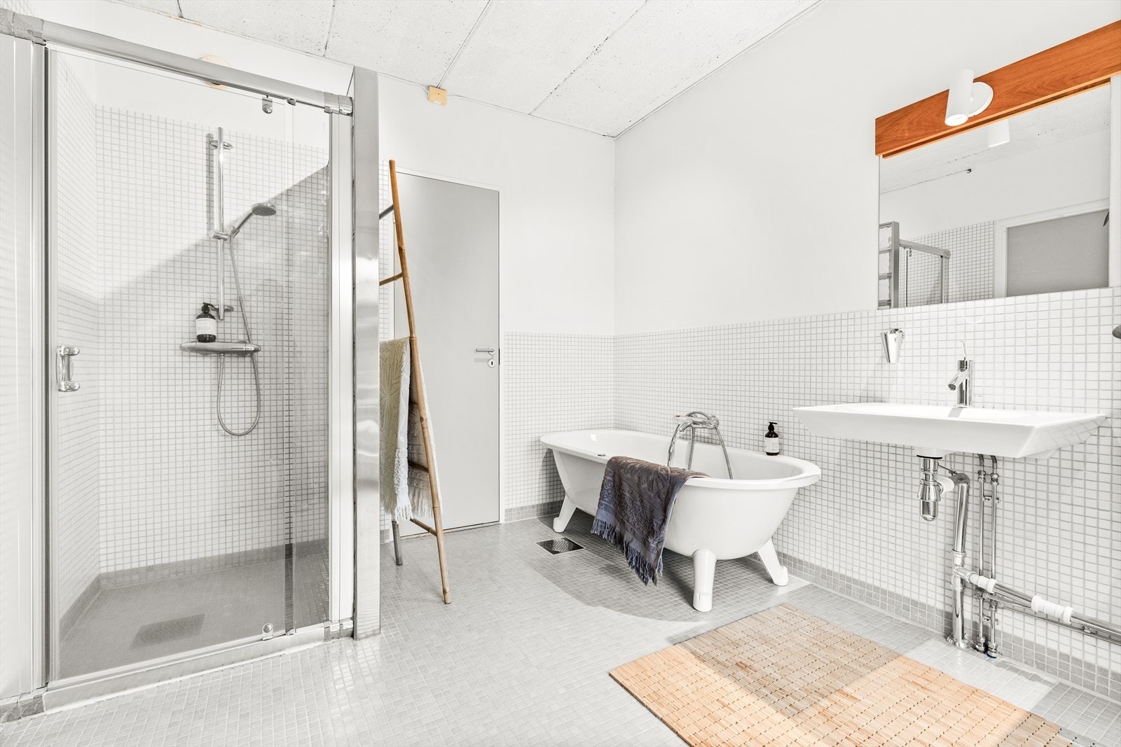 Badet er utstyrt med badekar, 2 servanter m/2 stk. ett-greps blandebatterier, dusjnisje med glassdør og speil med lys Galleribilde