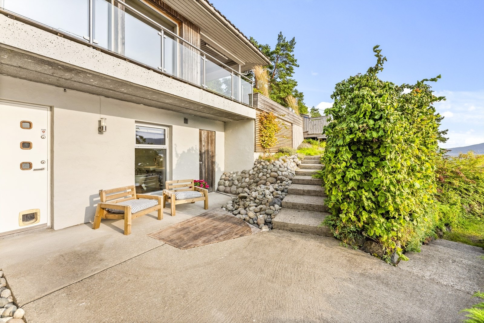 Eiendommen har flotte uteområder med både støpte og skiferlagte plattinger - her utenfor underetg. Galleribilde