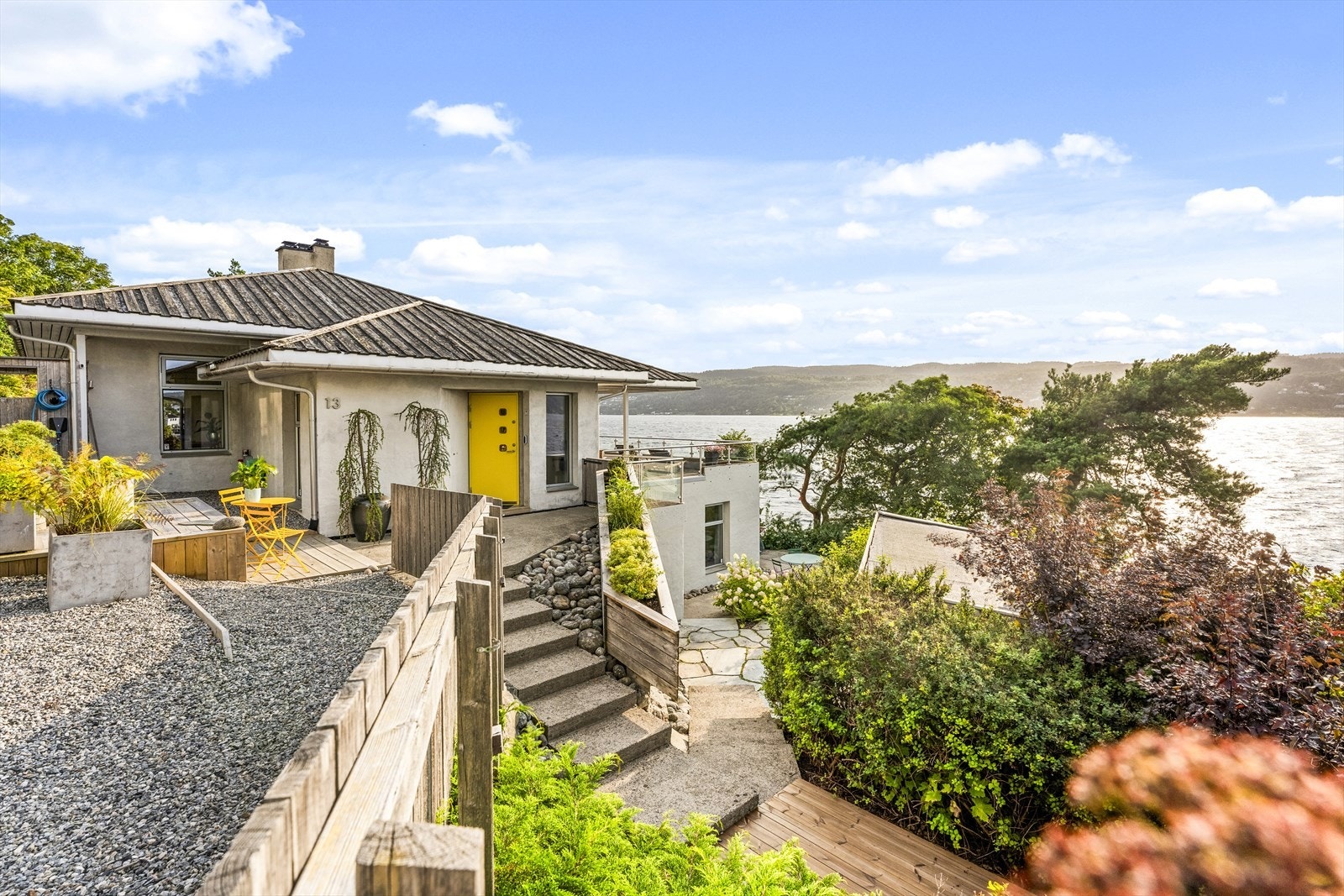 Tomten er pent opparbeidet med trapper i terrenget. plattinger og beplantninger Galleribilde