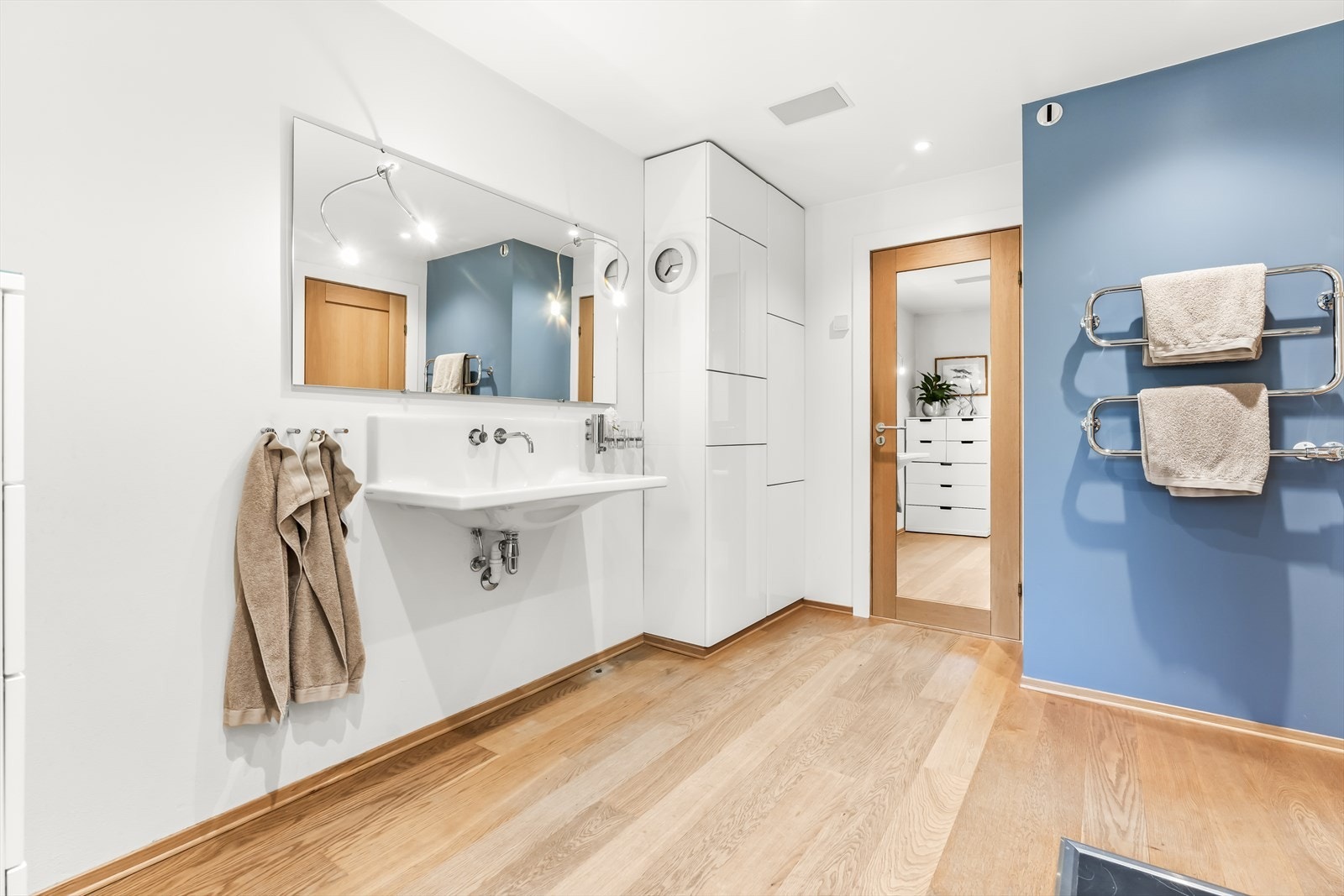 Badet har servant med ett-greps blandebatteri, og det er montert håndkletørker på veggen Galleribilde