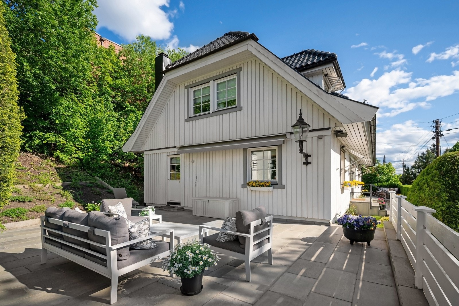 Høytliggende og velstelt tomt mot vest, med to store, skiferdekte markterrasser; sol fra formiddag til kveld. Galleribilde