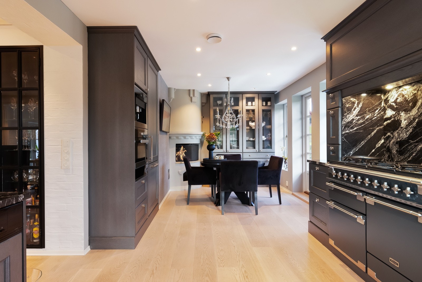 Kjøkkenet har god plass til et romslig rundt bord foran peis og vindusrekke.