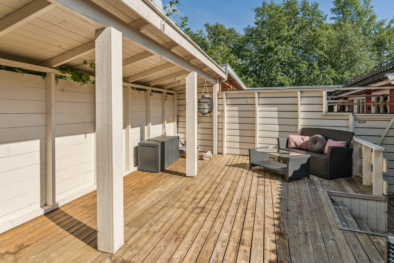 Terrassen har takoverbygg og levegg mot naboen. Galleribilde