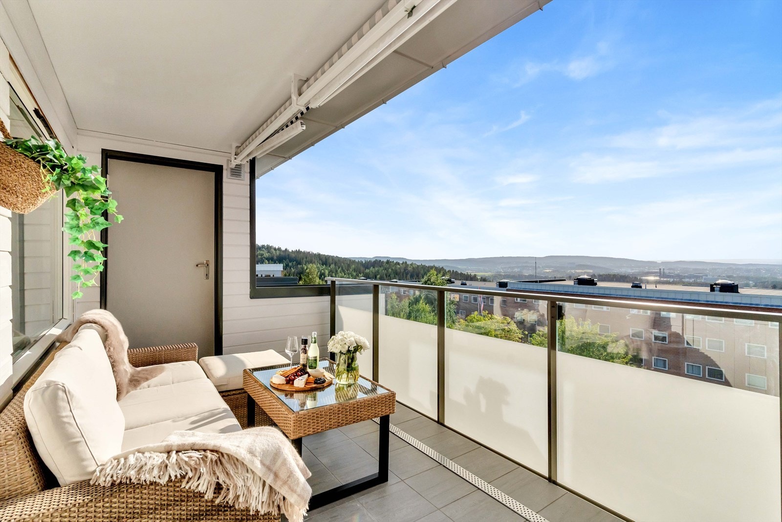 Balkongen har flislagt gulv og stilrent glassrekkverk. Galleribilde