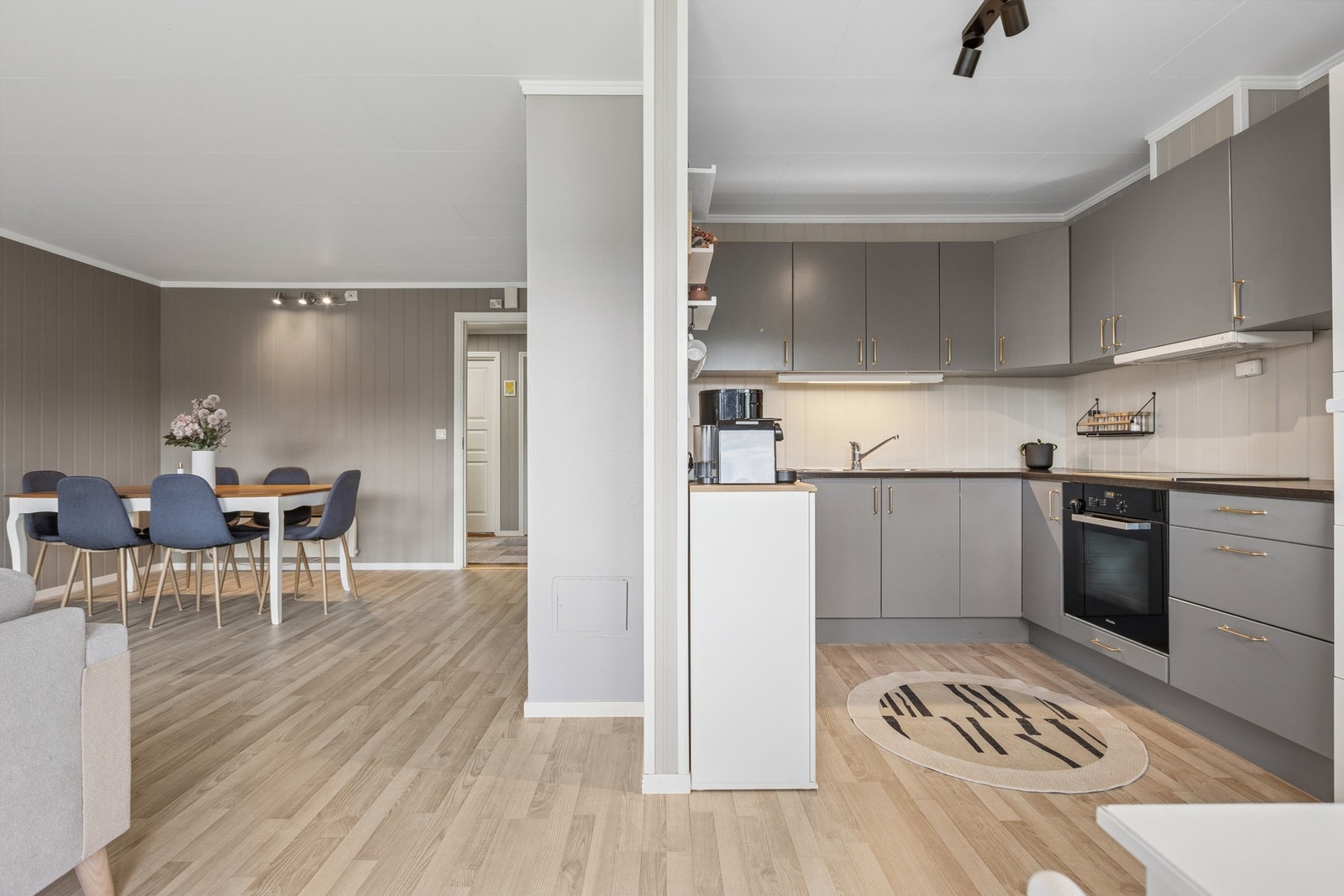 Delvis åpen kjøkkenløsning som gir en god kombinasjon av sosialt preg og praktisk avgrensning. Galleribilde