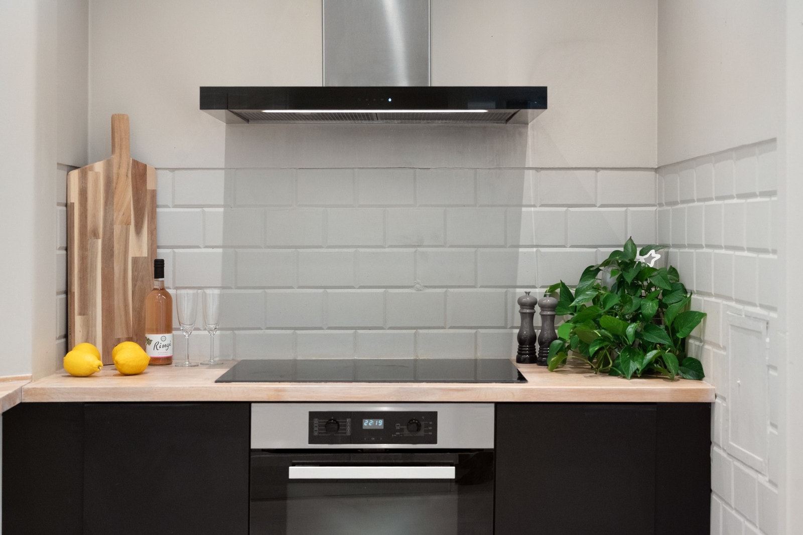 Denne delen av kjøkkenet har svarte fronter og integrert platetopp og stekeovn. Galleribilde