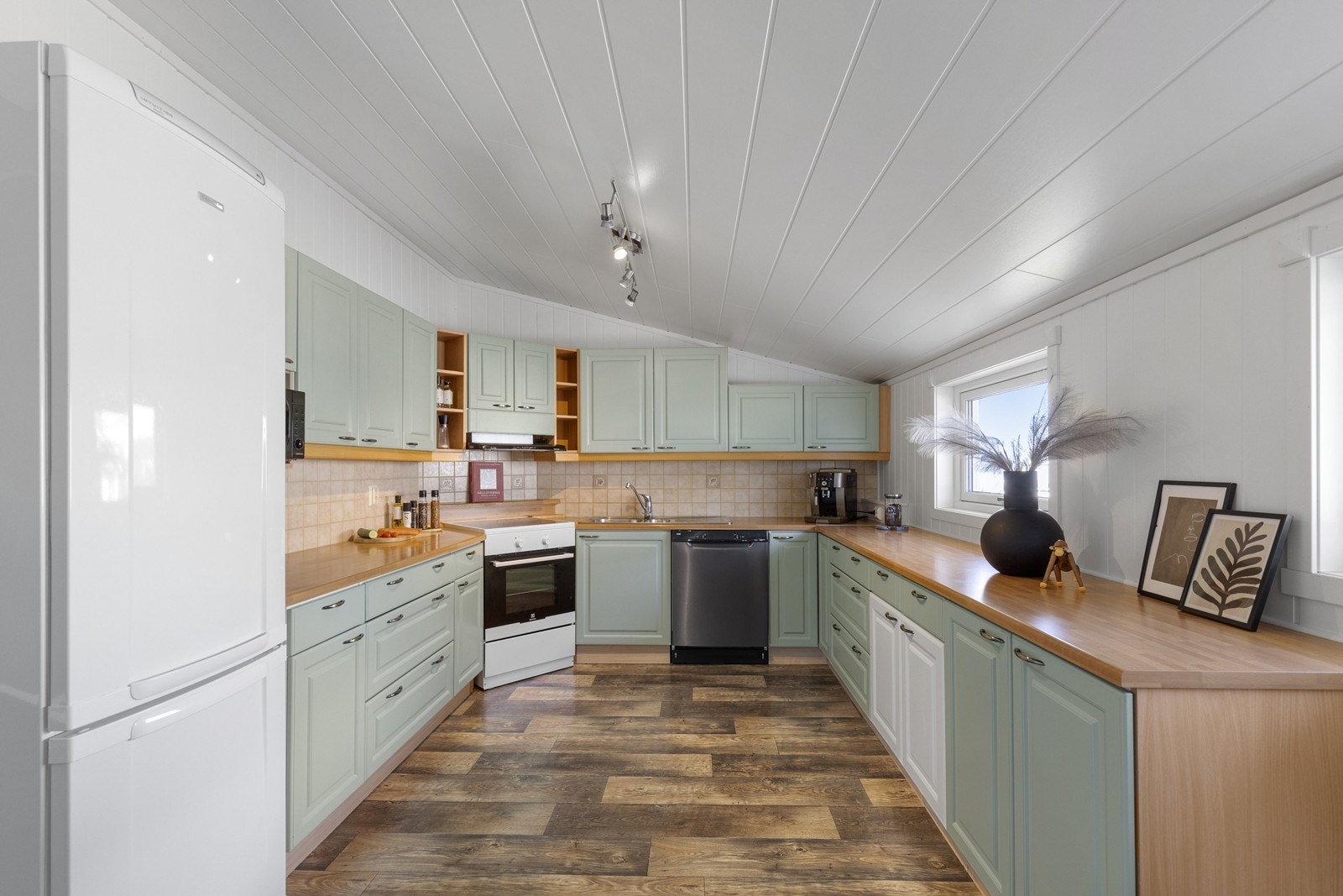 Kjøkken med frittstående hvitevarer og god plass Galleribilde