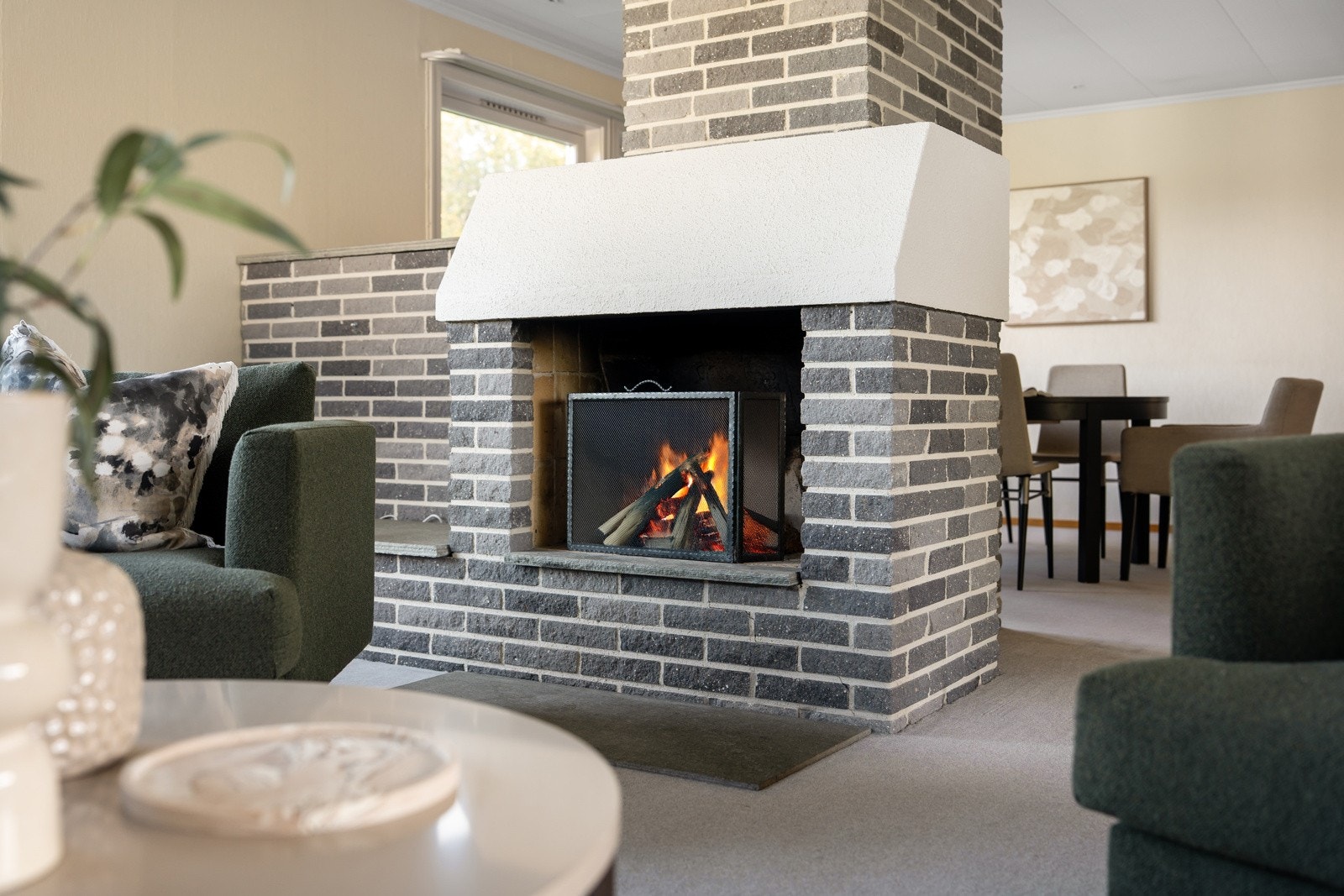 Kombinasjonen av peis, grønne innslag og rikelig lysinnslipp gir rommet en harmonisk balanse. Galleribilde