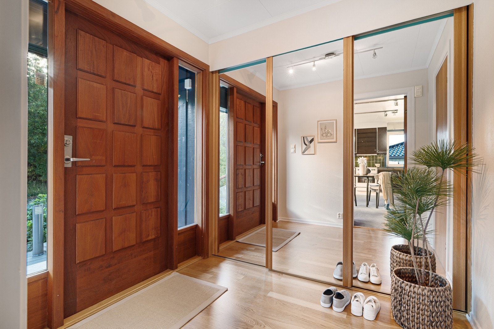 Innbydende entré med varme trefarger, naturlig lysinnslipp og en praktisk, innebygd skyvedørsgarderobe. Galleribilde