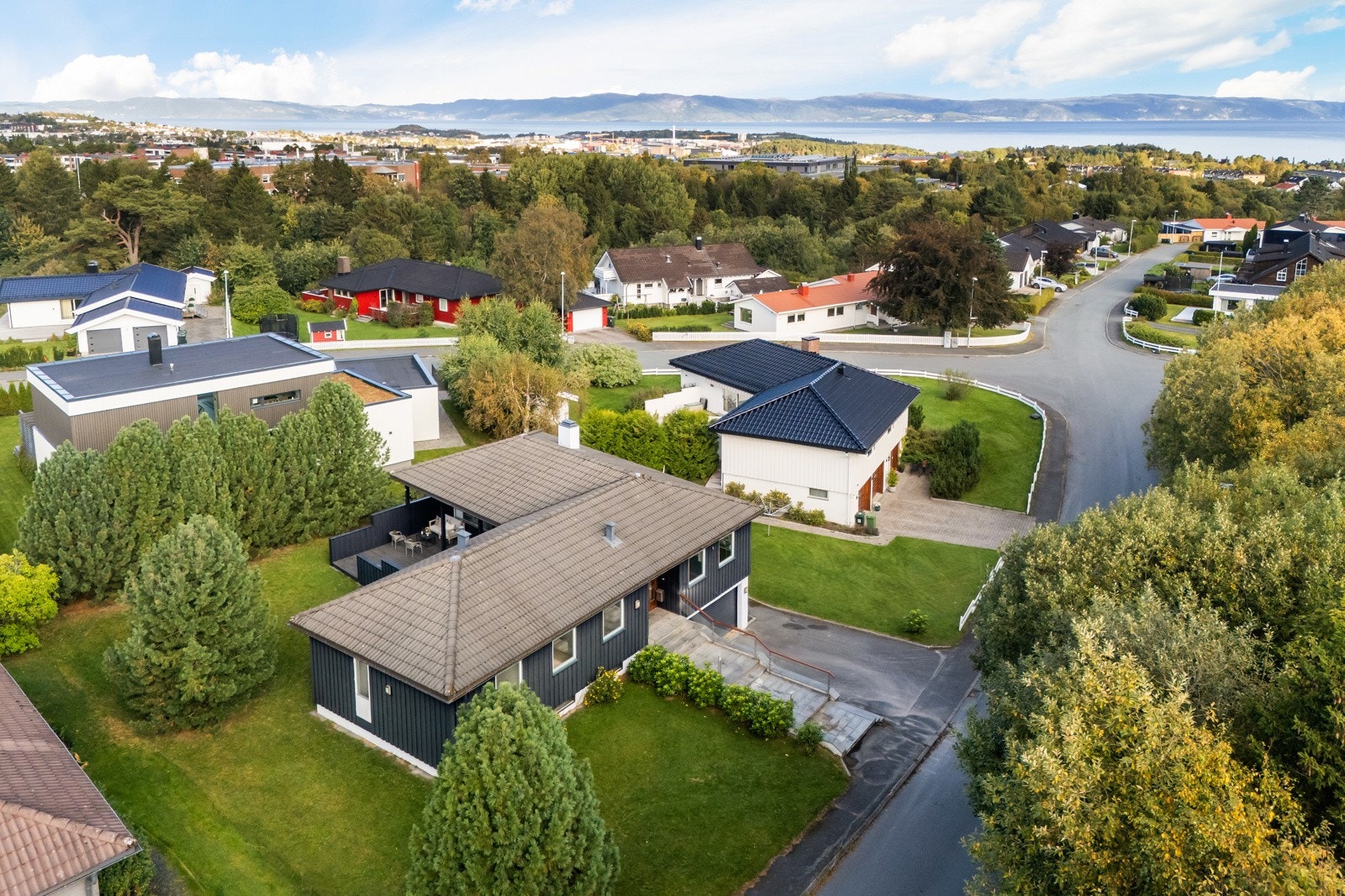 Tomten er pent opparbeidet med stor hage og frodig beplantning som skaper en grønn og idyllisk atmosfære. Galleribilde