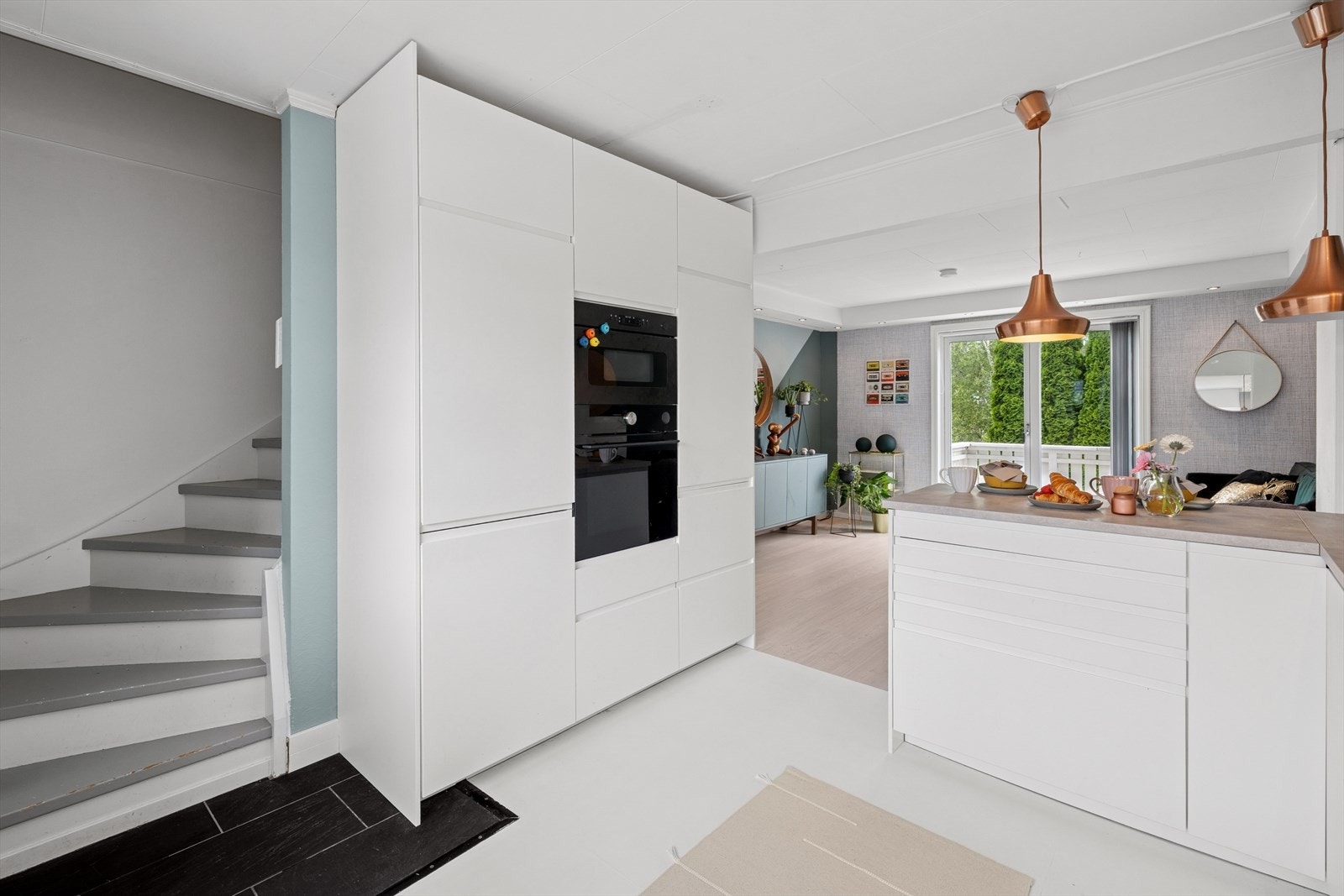 Kjøkkeninnredning med glatte fronter og laminert benkeplate. Det er kjøkkenventilator med avtrekk ut. Galleribilde